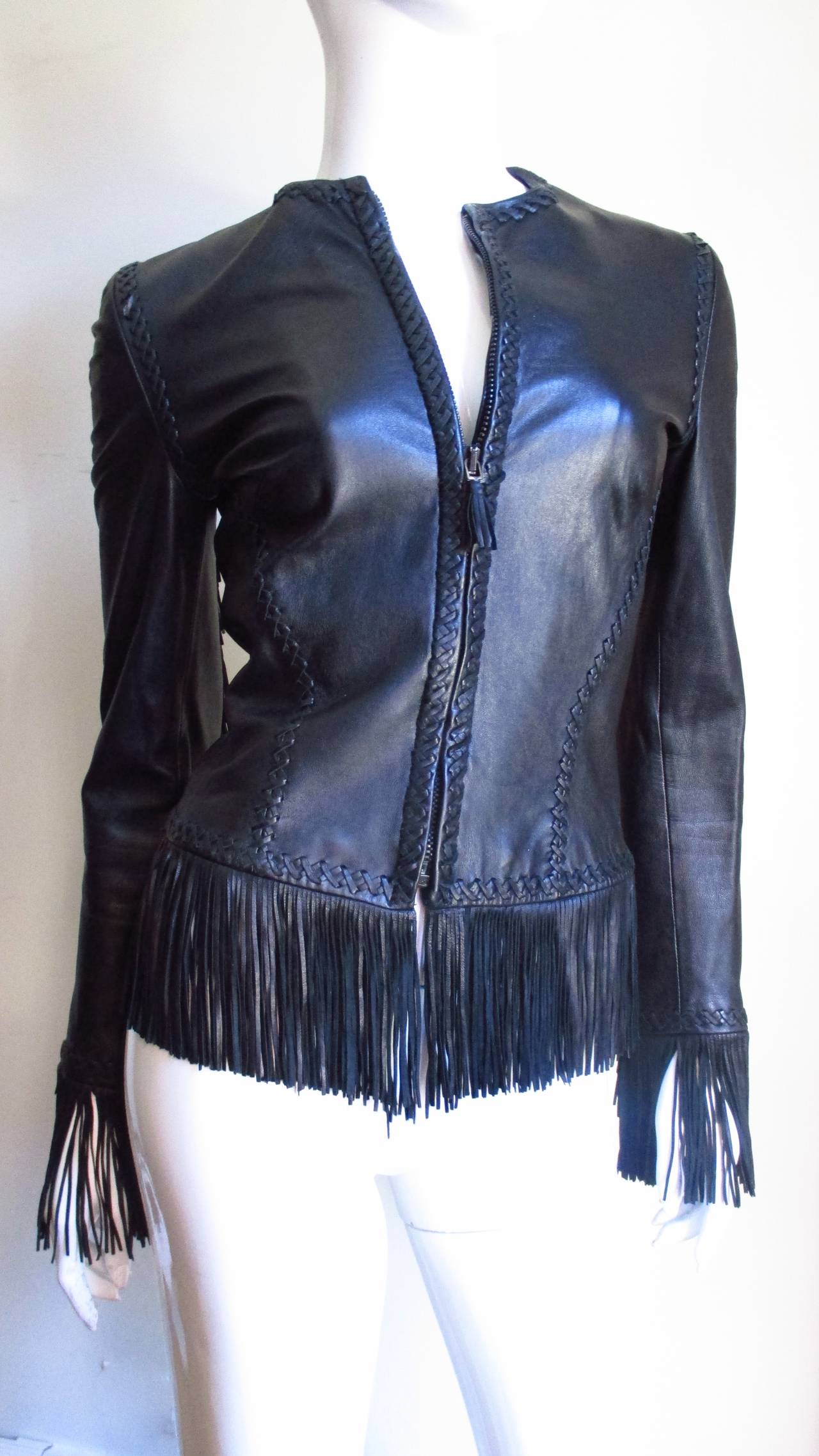 One of Gianni Versace's earlier masterpieces in this supple, soft black leather fringe jacket.  It is fitted with seaming which along with hems and edges are highlighted with intricate hand braiding plus 4