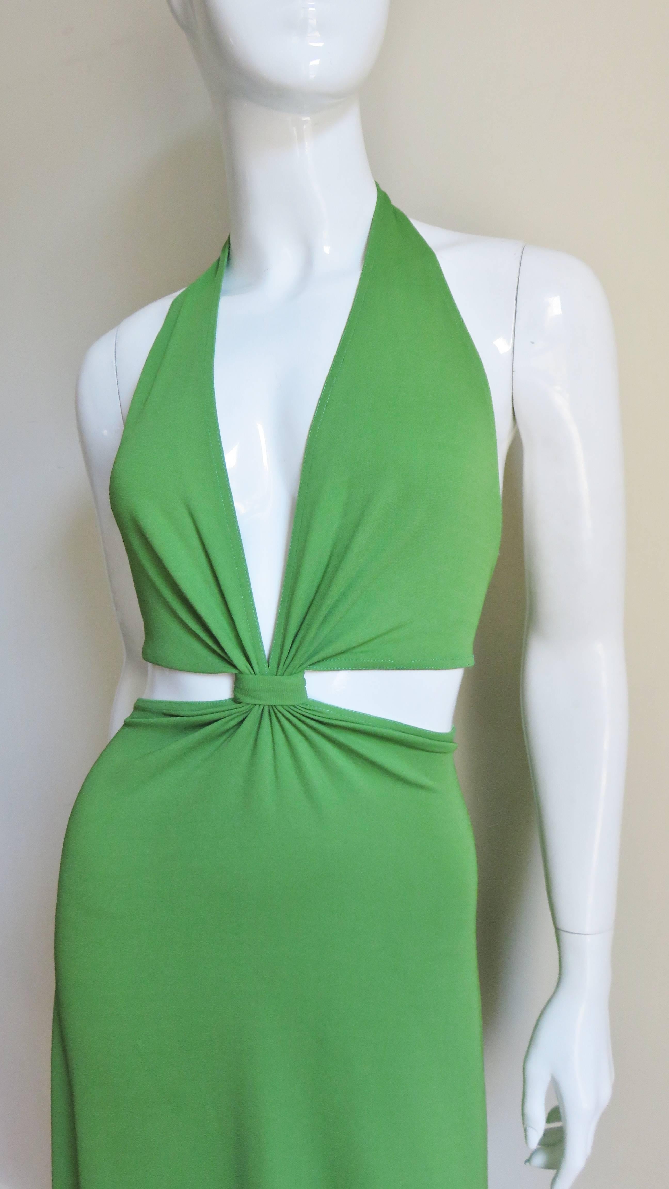 A fabulous bright green silk jersey dress from Celine. It has a halter style top with a plunging front and bare in the back with the exception of a strap across the center closing with a metal clasp. The skirt forms from the gathered center front of