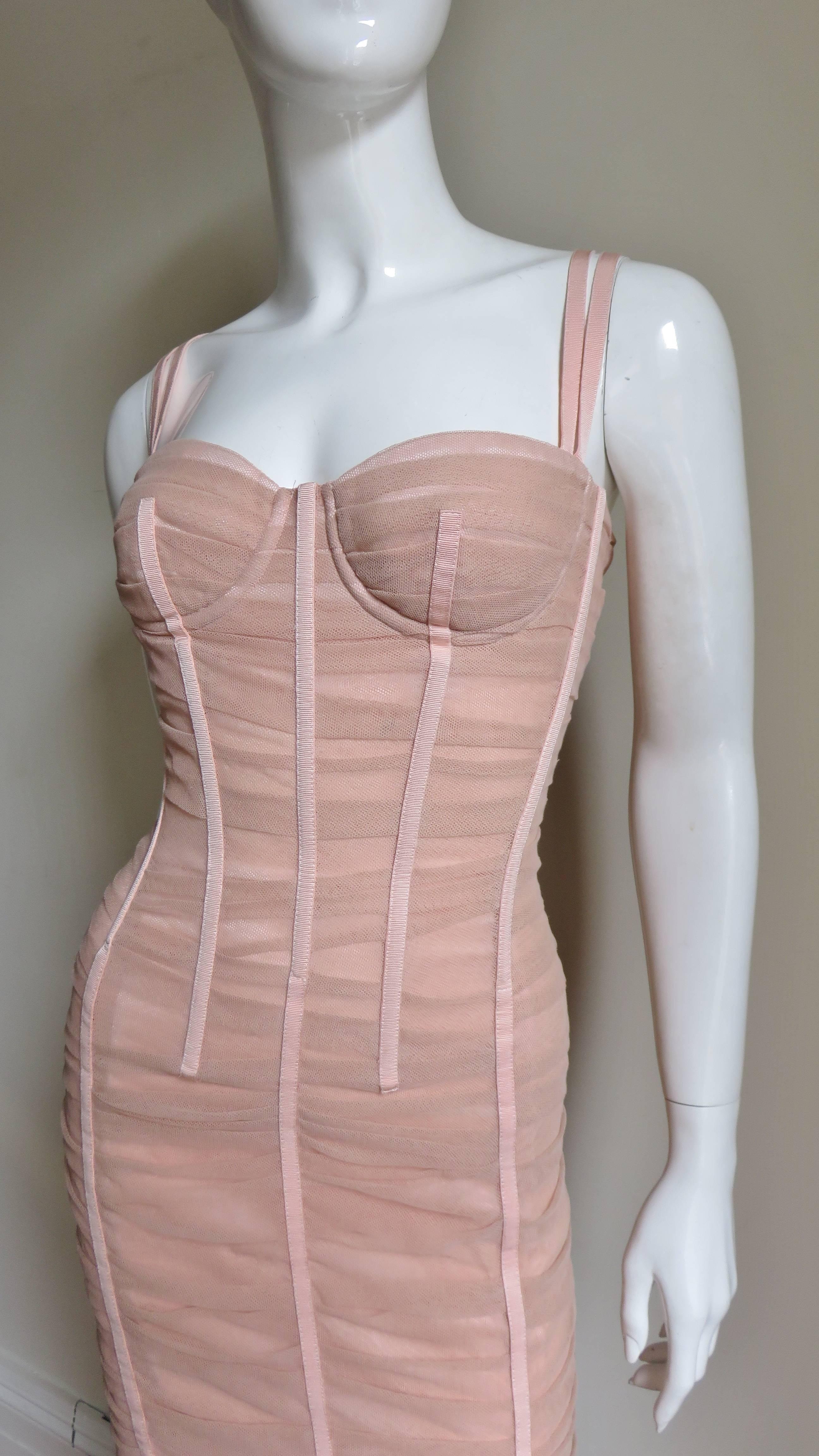 A fabulous pink silk dress from Dolce and Gabbana.  It has a bodice with bust cups and double straps which form a V in the back.  The bodice has boning which is incorporated into the design.  Between the fitted panels of the dress and the boning is