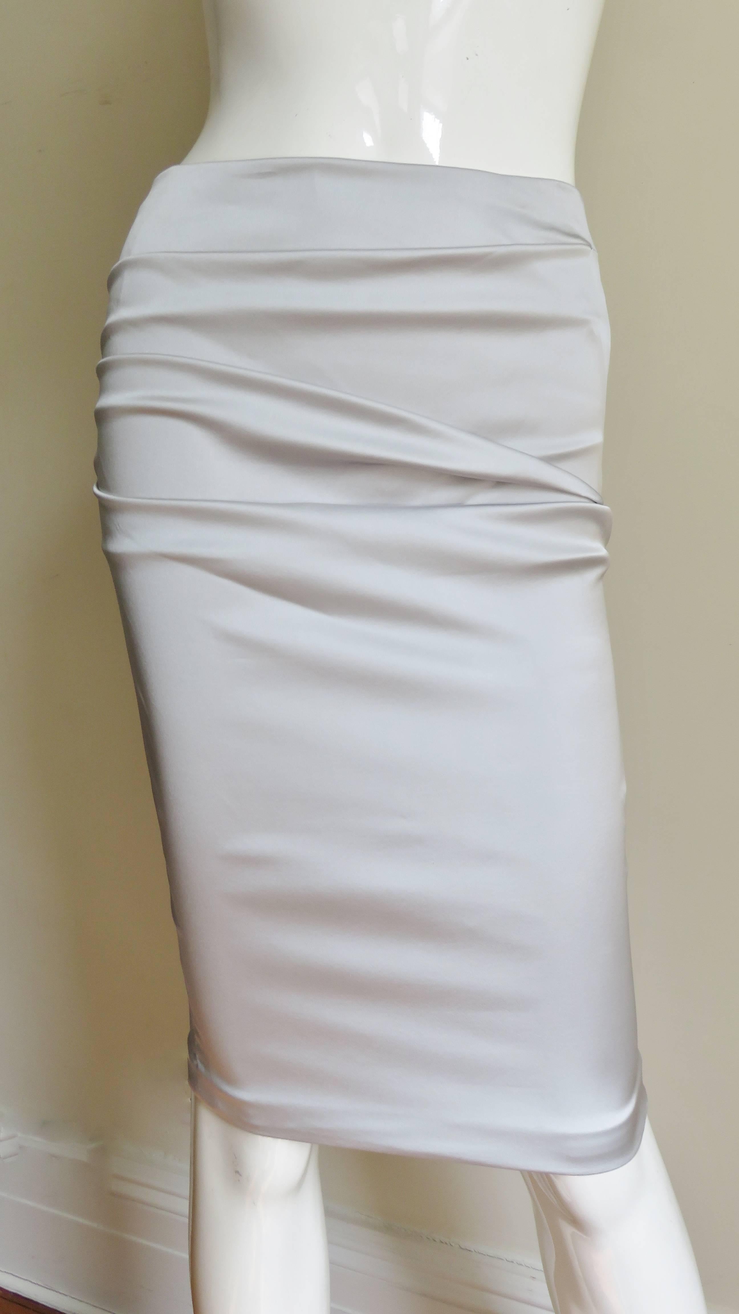 A gorgeous light grey stretch silk skirt from Dolce & Gabbana.  It is a pencil style skirt with horizontal ruching across the front and back.  There is functional lacing along the center back length of the skirt. It has a matching center back