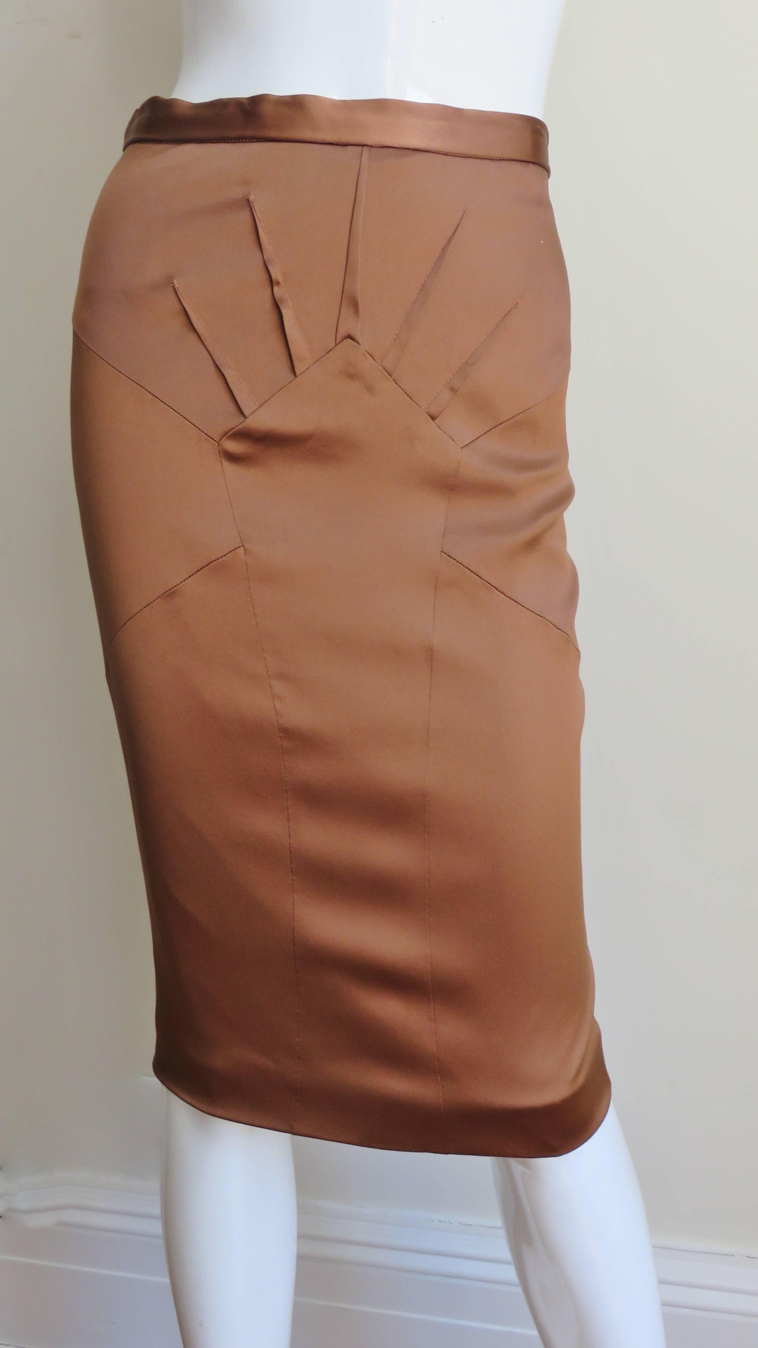 A beautiful copper brown stretch silk pencil skirt from Dolce & Gabbana. It has a waist band plus fabulous seaming and darts radiating from a center front panel.  It is lined in same fabric, has a back kick pleat at the hem and a center back