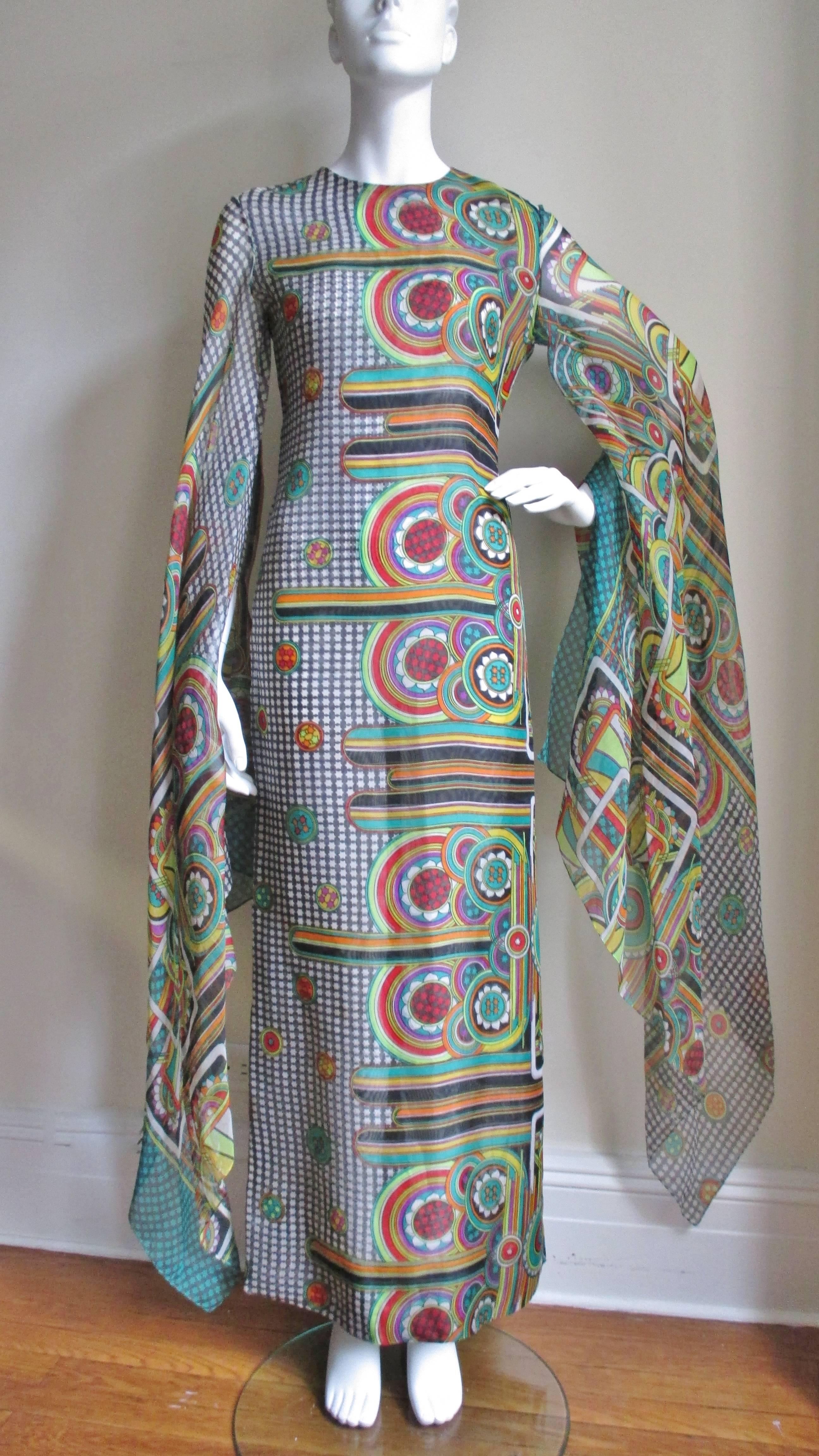 Absolutely incredible vibrantly colored silk abstract patterned dress from Pierre Cardin. Full length skimming the body with incredible floor length angel sleeves. The pattern is a work of art and different on each side of the front and back of the