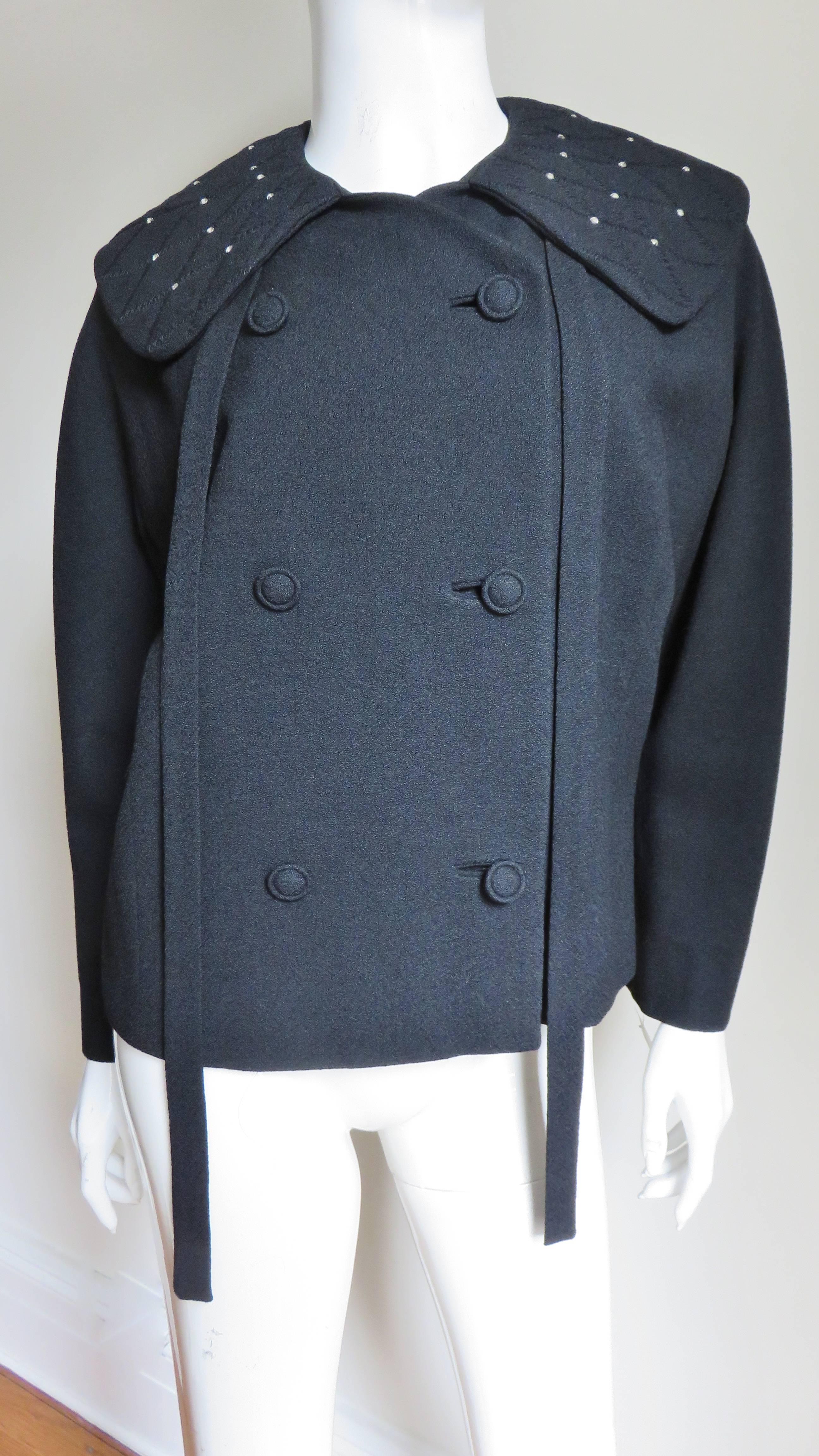 A great black wool jacket by Lilli Ann. The large collar has ties and is top stitched in a diamond pattern with prong set rhinestones at the points.  It is double breasted with self covered buttons and bound buttonholes. The sleeves are raglan style