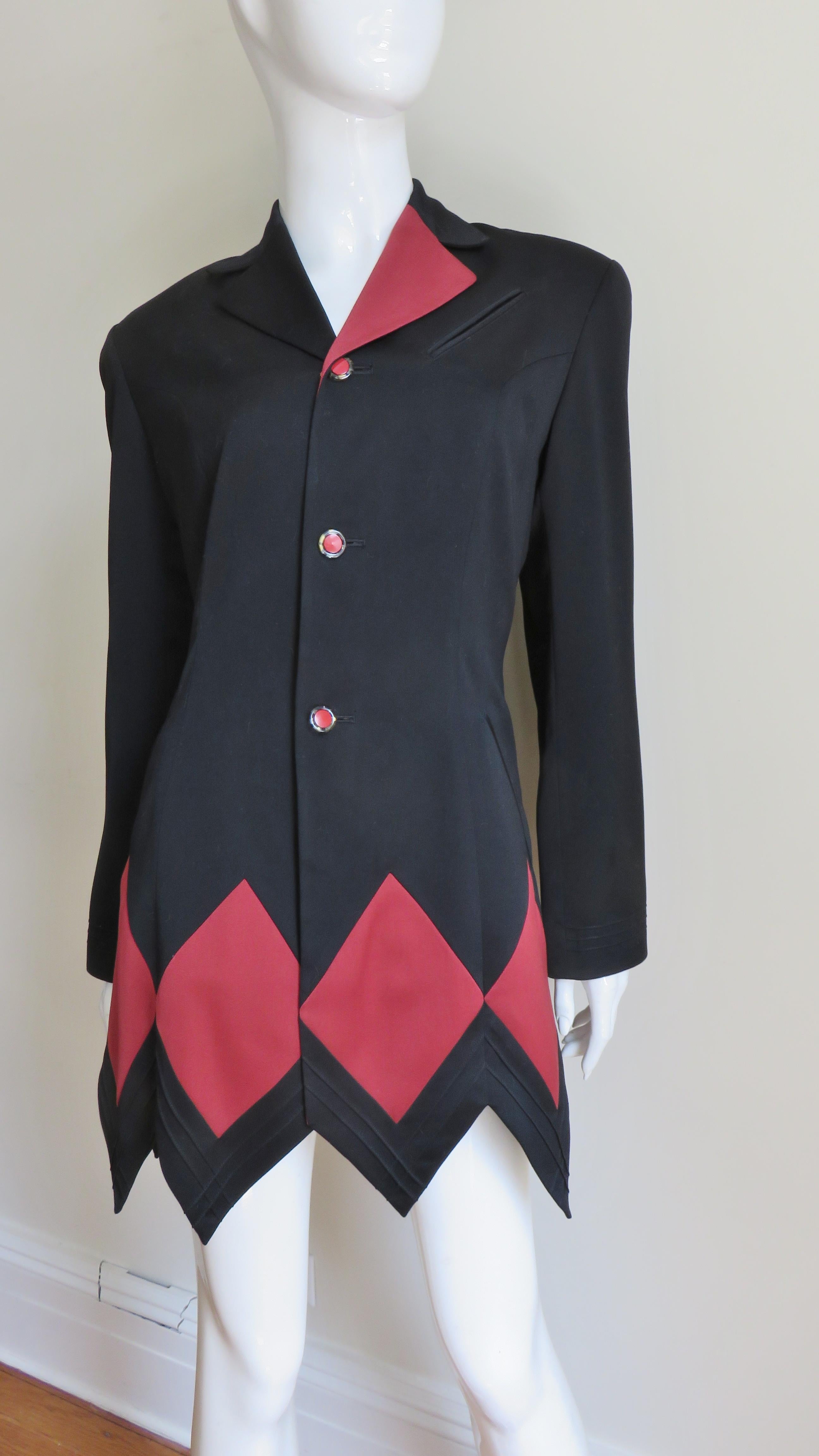 Eine fabelhafte schwarze Wolljacke mit einem roten Harlekin-Patchwork-Muster.  Sie hat einen Reverskragen, der auf der einen Seite rot und auf der anderen schwarz ist, leichte Schulterpolster und einen Zickzack-Saum, der den Linien der einzeln