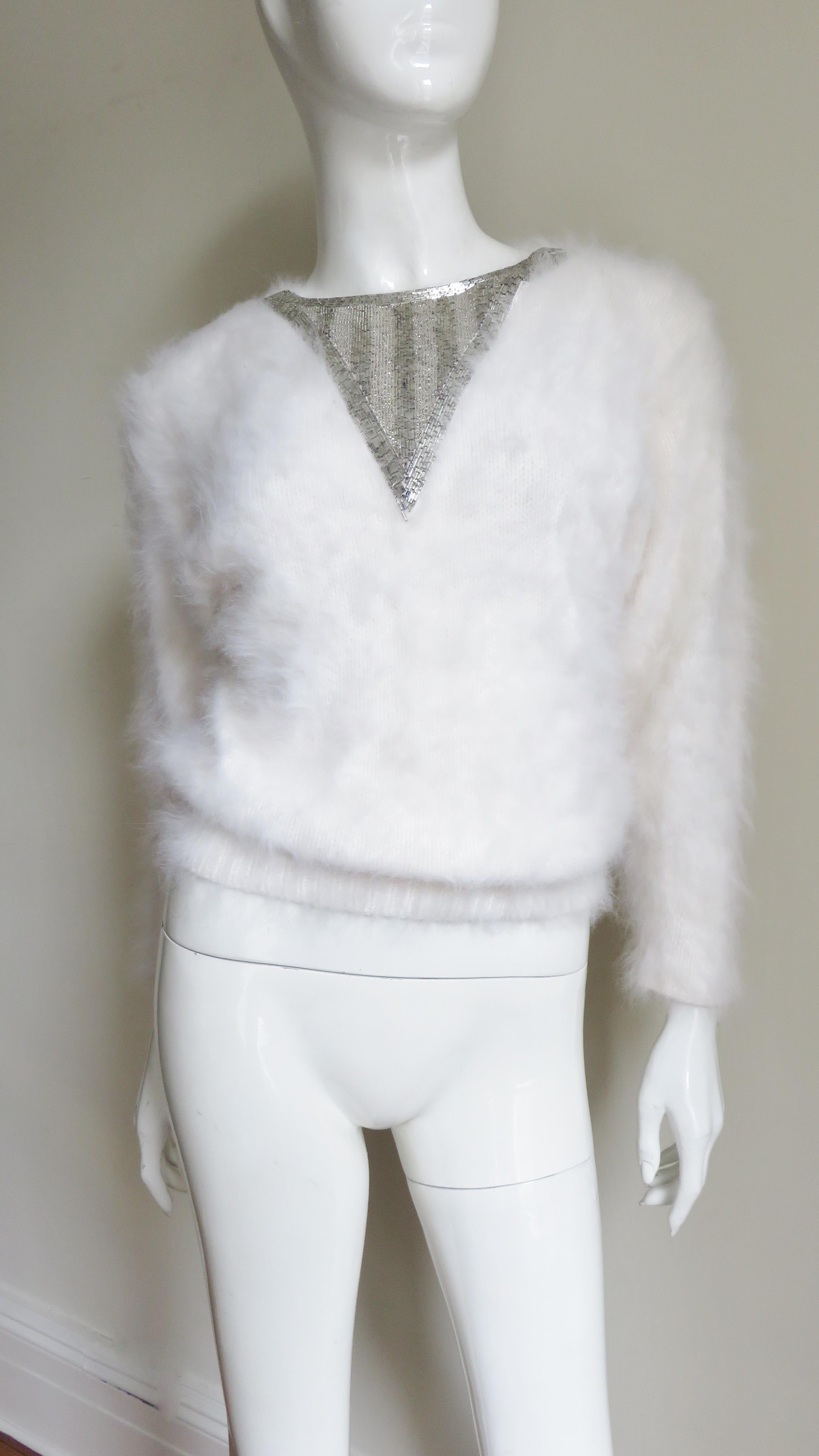A very pretty white angora sweater from J. J. Or.  It has a silver glass beaded V inset at the center front neck and pearl button closing at the back neck.
Unworn.  Fits sizes Extra Small, Small, Medium.

Bust  36-38