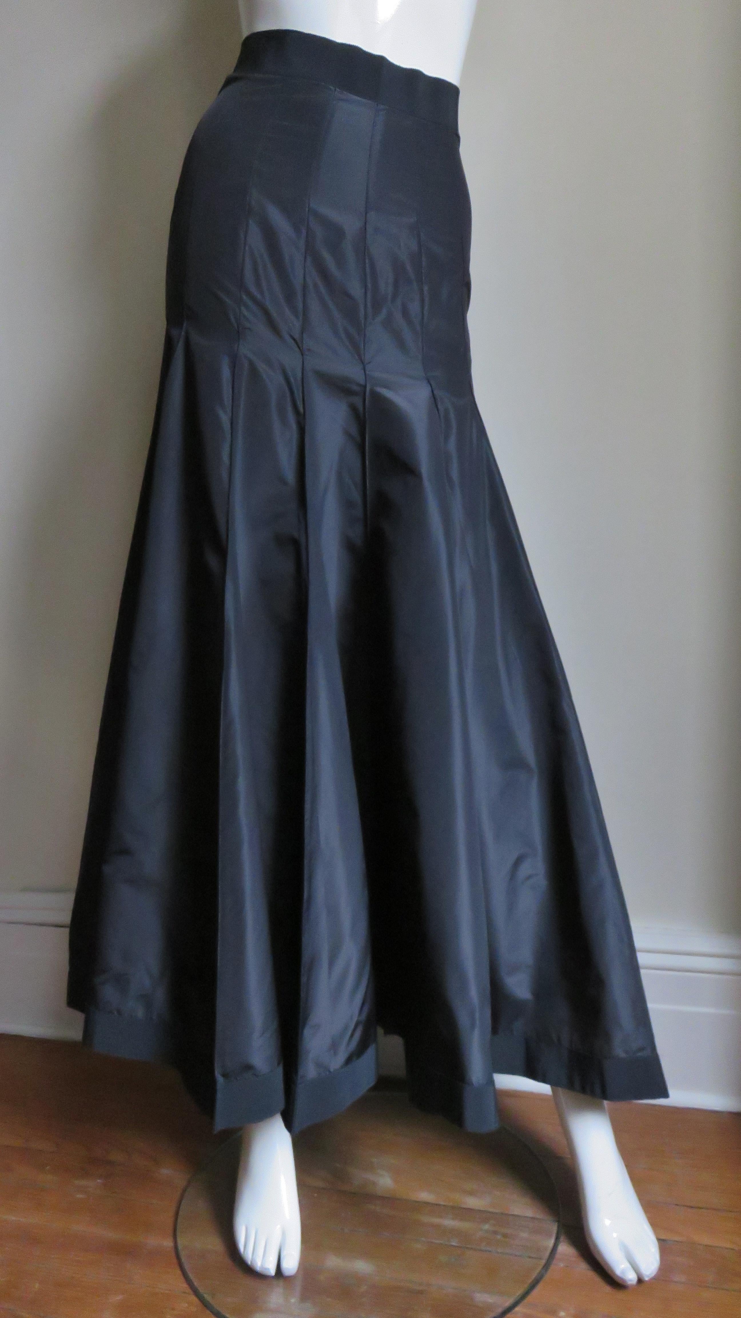 A beautiful black silk taffeta skirt from Angelo Tarlazzi.  It has a grosgrain waistband and vertical panels semi fitted though to the hips then flaring to the hem.  The skirt has grosgrain around the hem also and it is unlined with a center back