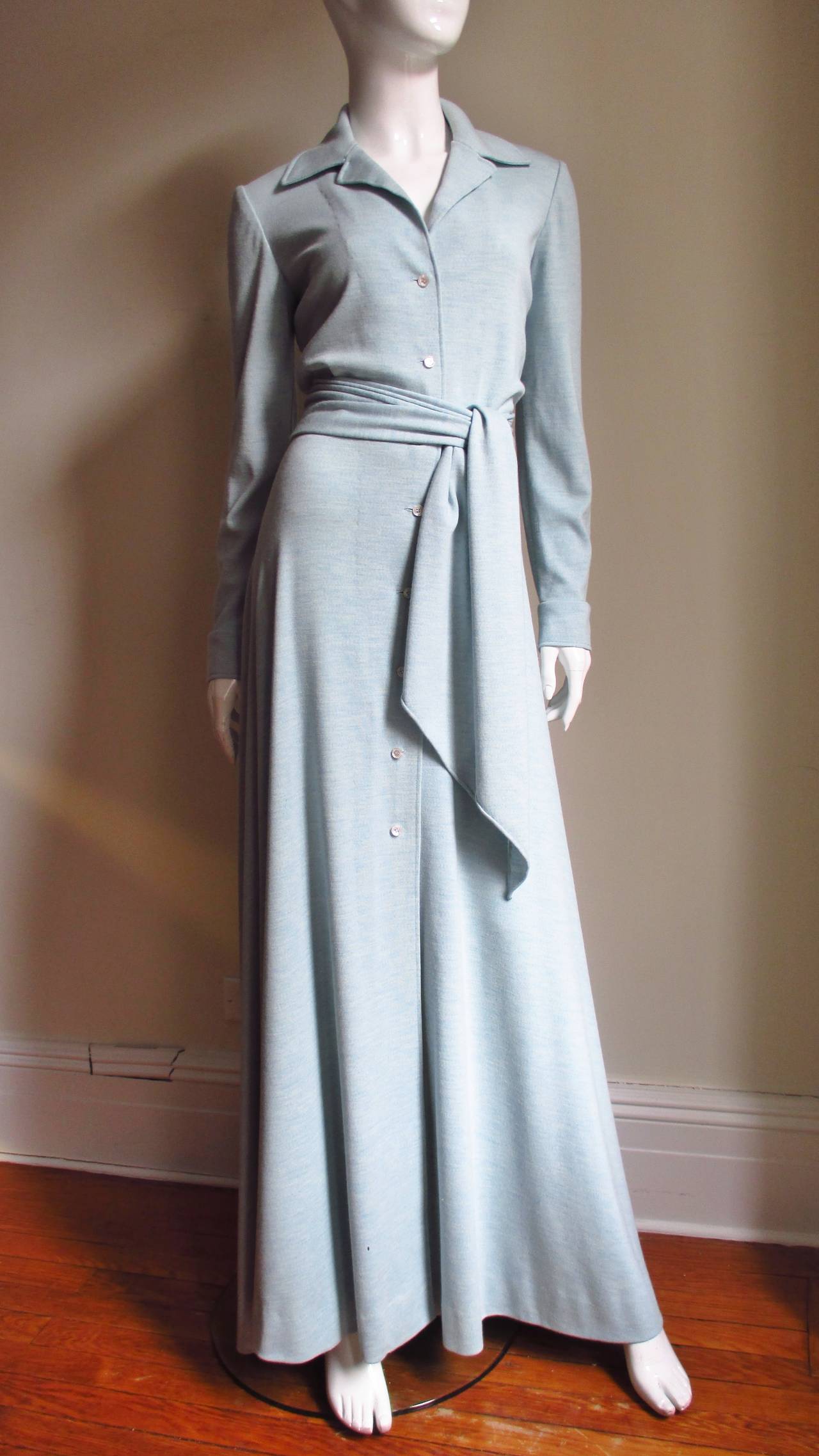 An absolutely gorgeous baby blue cashmere wool blend jersey maxi dress by Halston. It has an open collar, long sleeves with button cuffs and a matching wide tie belt. The skirt flares towards the hemline and the dress buttons up the front. It is