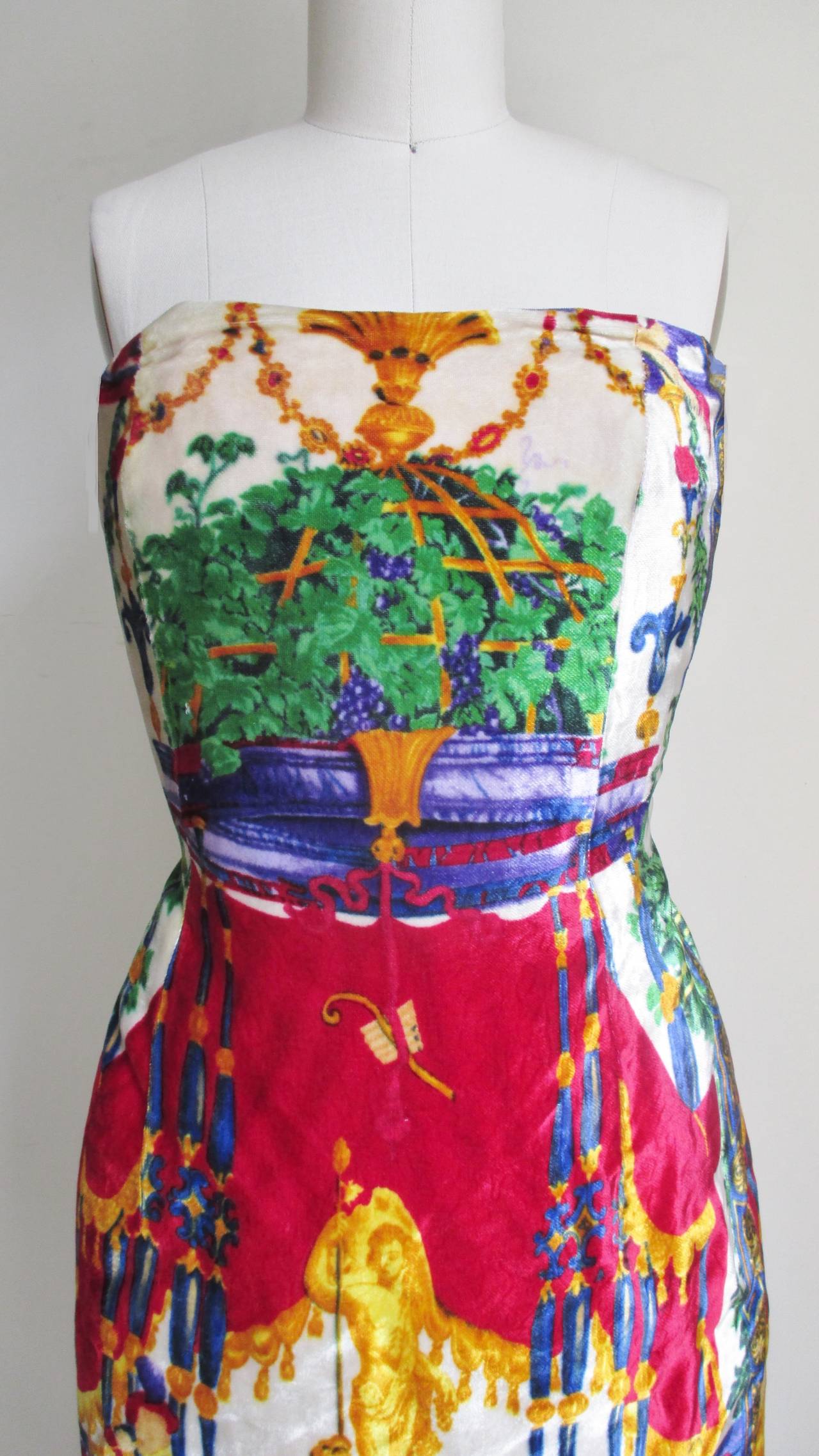 Beautiful, simple silk velvet strapless dress intricately patterned in the brightly colored elaborate detail that Versace was famous for- maidens, flora, fauna, statues set against elaborate backdrops (the front of the dress different than the