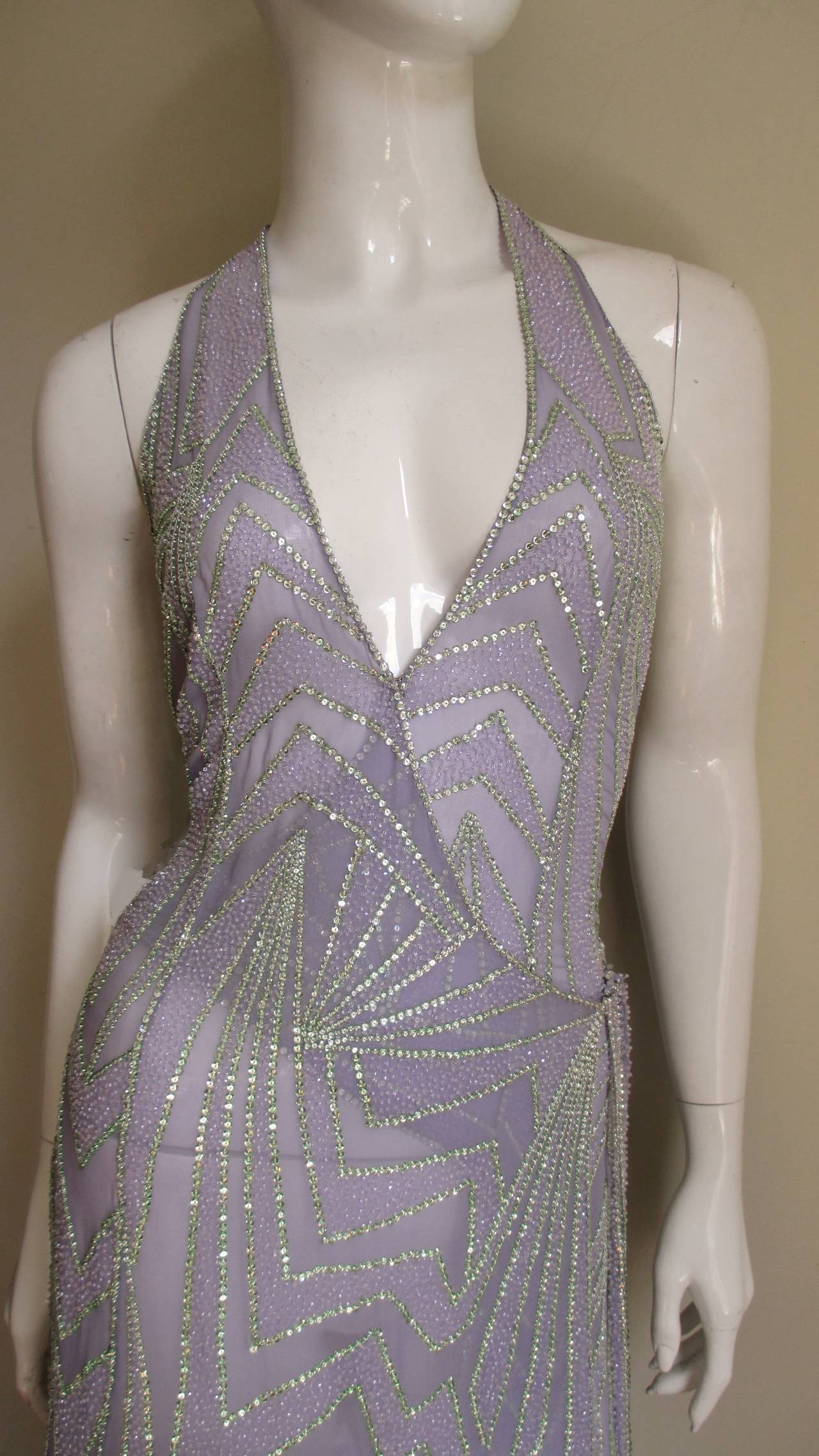 Exquisitely detailed beaded, sequin silk dress from Gianni Versace Couture. It is a plunging neck halter wrap style in a beautiful abstract pattern of lines and angles on pale lilac semi sheer silk outlined with pale green sequins, the areas in