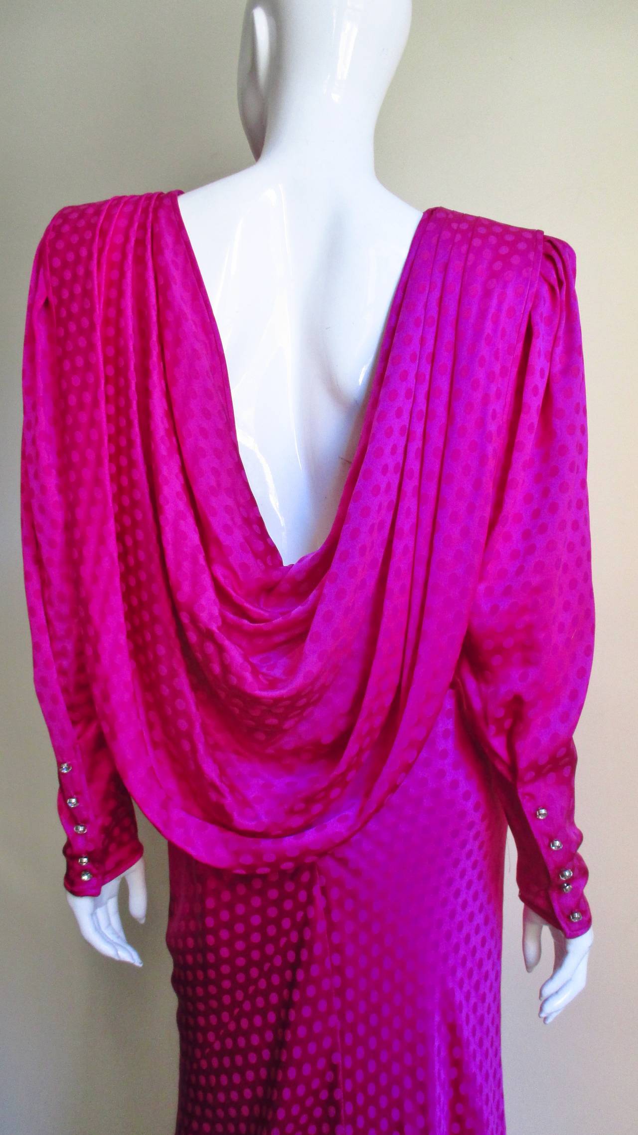 Dramatic and beautiful vibrant fuchsia silk dress with a subtly embossed dot pattern from Emanuel Ungaro Parallele. Simple padded shoulders long sheath from the front.  The low cut back is surrounded by folds of weighted draping to the hips and has