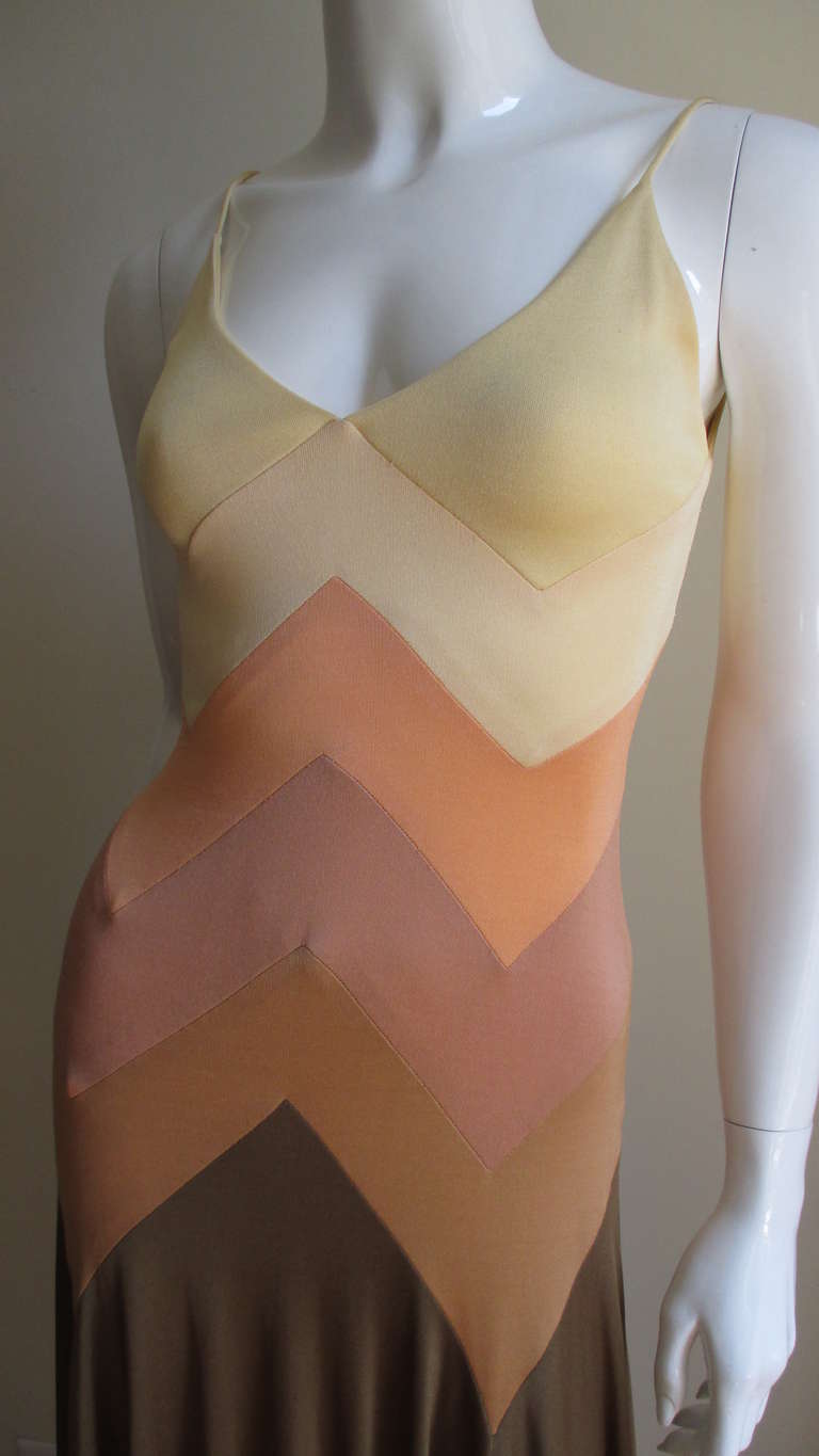 Flattering fitted spaghetti strap synthetic knit dress in yellows, peach, tan, muted rose and brown each sewn in a chevron pattern around the dress.  It is a fitted dress through the hips and flared gracefully to the hem.  The neckline is V cut with