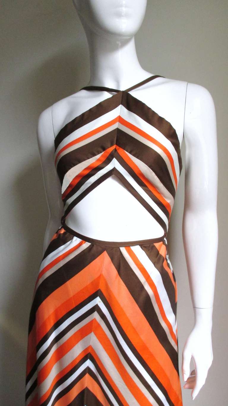 Fabulous cutout midriff maxi in bright varying width stripes in oranges, brown, beige and white made of a polished cotton/silk blend which show the colors beautifully.  The dress has a triangular brown edged cutout at the waist plus a pieced and