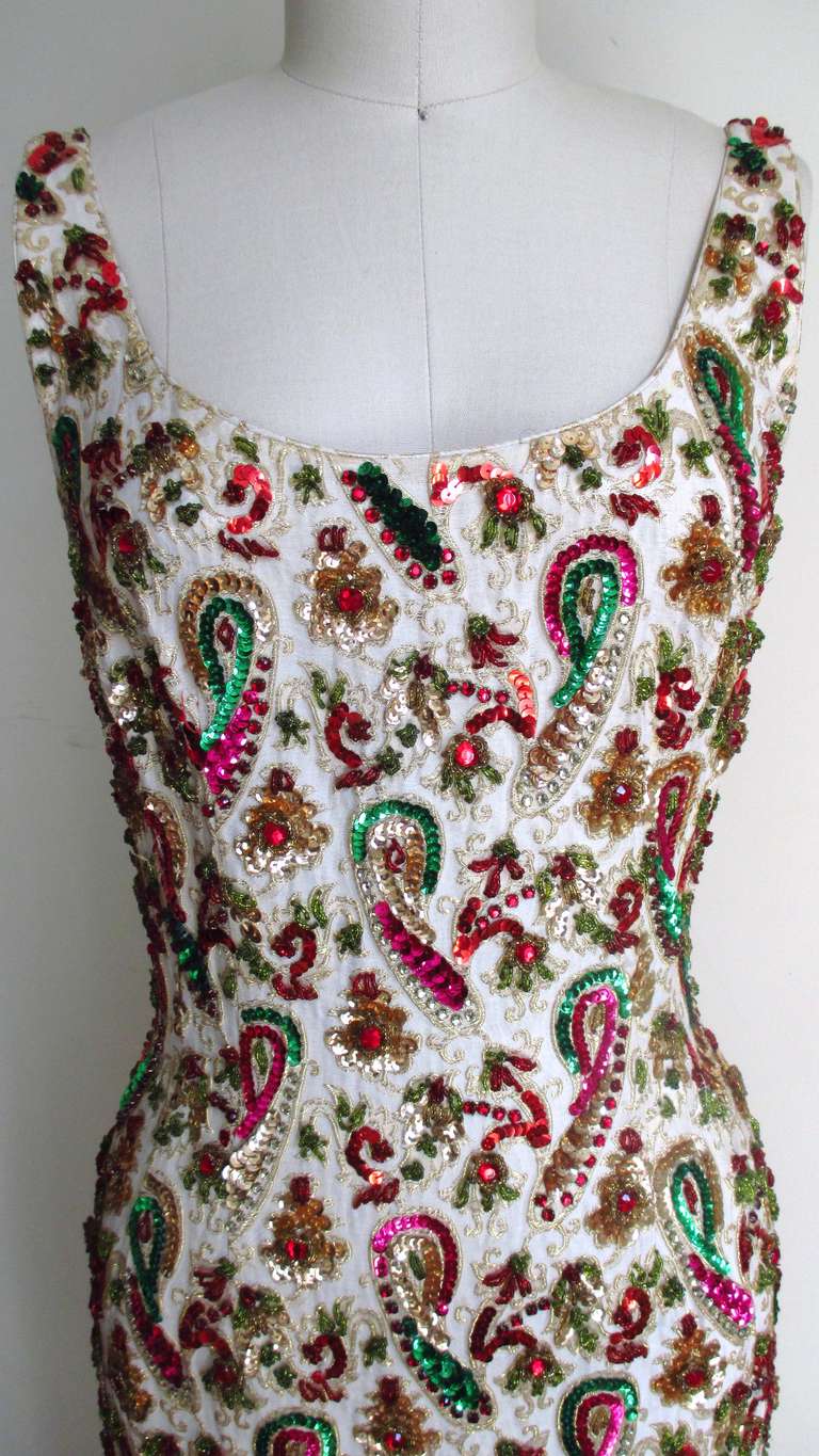 Some of the most beautiful hand detailed bead/sequin work came out of 1960's Hong Kong.  It is a simple full length gown with a scoop neck front and back.  It is fitted though the hips then falls strait to the hem.  There is a side slit for ease of