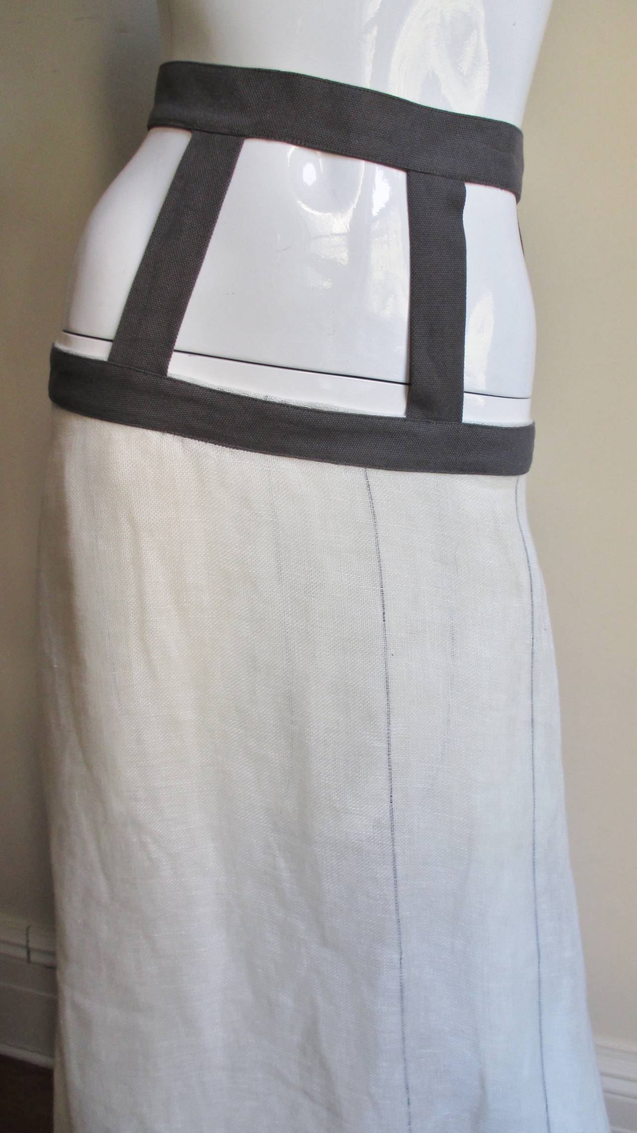 This is an amazing skirt from cutting edge designer Paul Skedd.  It is made of off white linen with intermittent grey vertical stripes matching the skirt's yoke consisting grey linen bands at the waist and hips joined together with 4 vertical bands