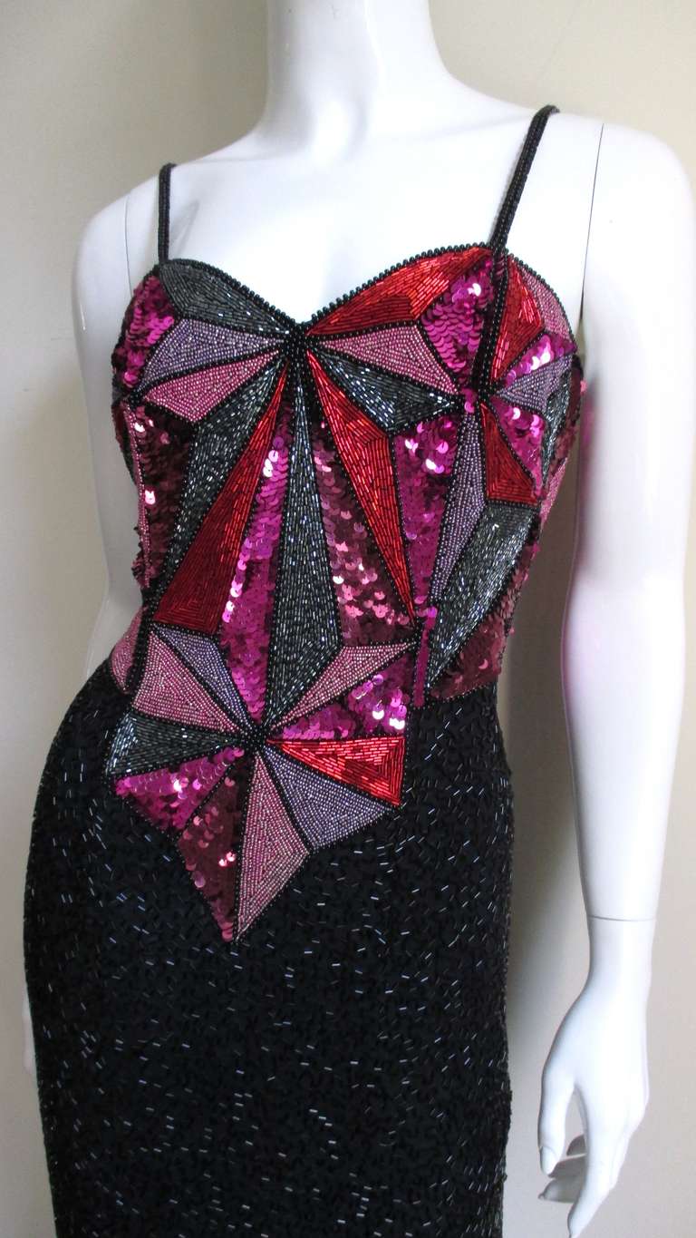 A beautiful silk cocktail dress from Christian Lacroix with elaborate beading and sequins in magenta, rose, silver and red with a beaded black skirt.  The sweetheart cut bodice has beaded spaghetti straps and an intricate pattern of lines and angles