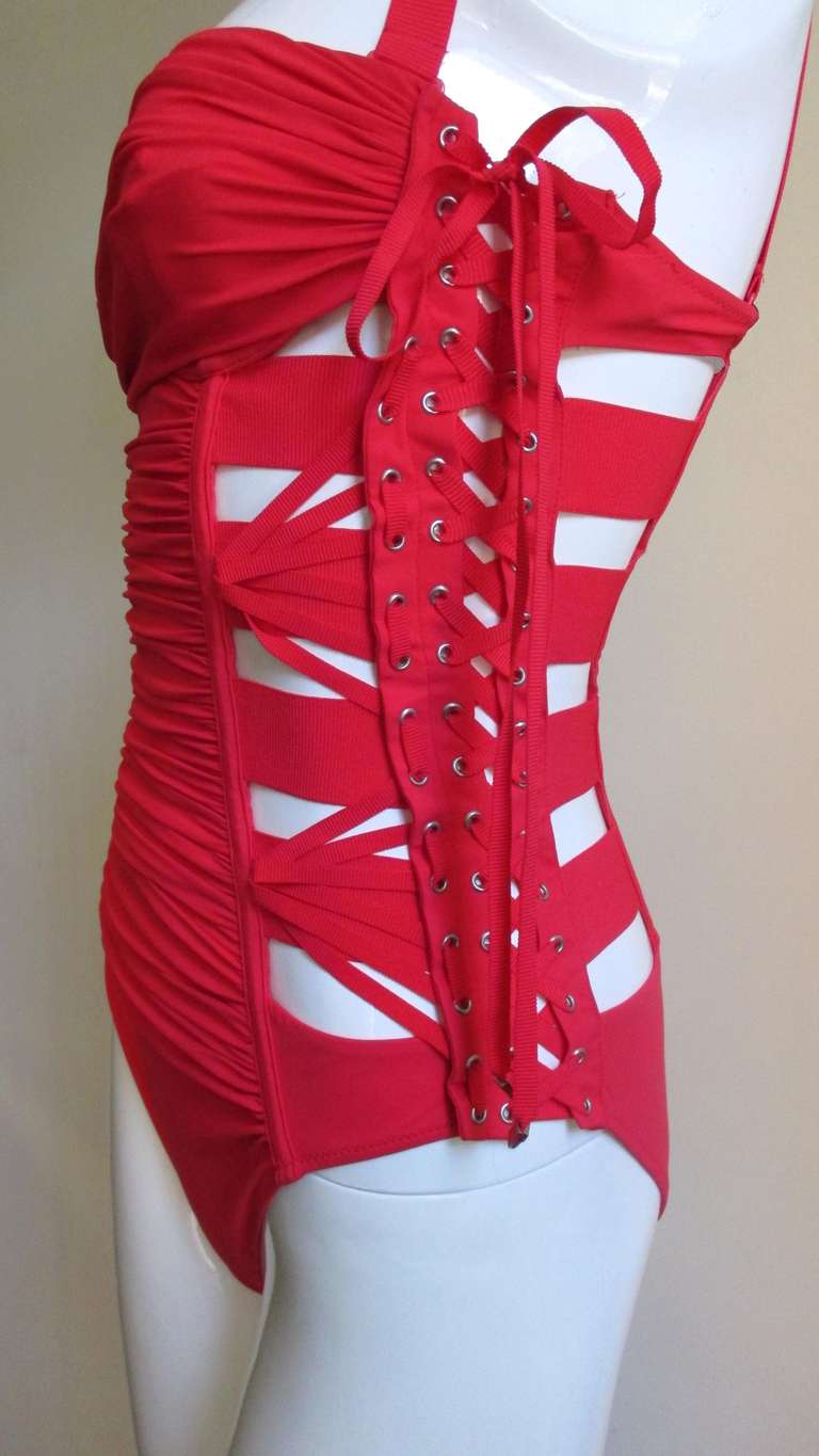 From Jean Paul Gaultier for La Perla an amazing red swimsuit.  An enormous amount of detail, adjustable lacing up each side, multi angle lacings on the front sides and ruching in between.  It has a demi underwire bra under a band of ruching for