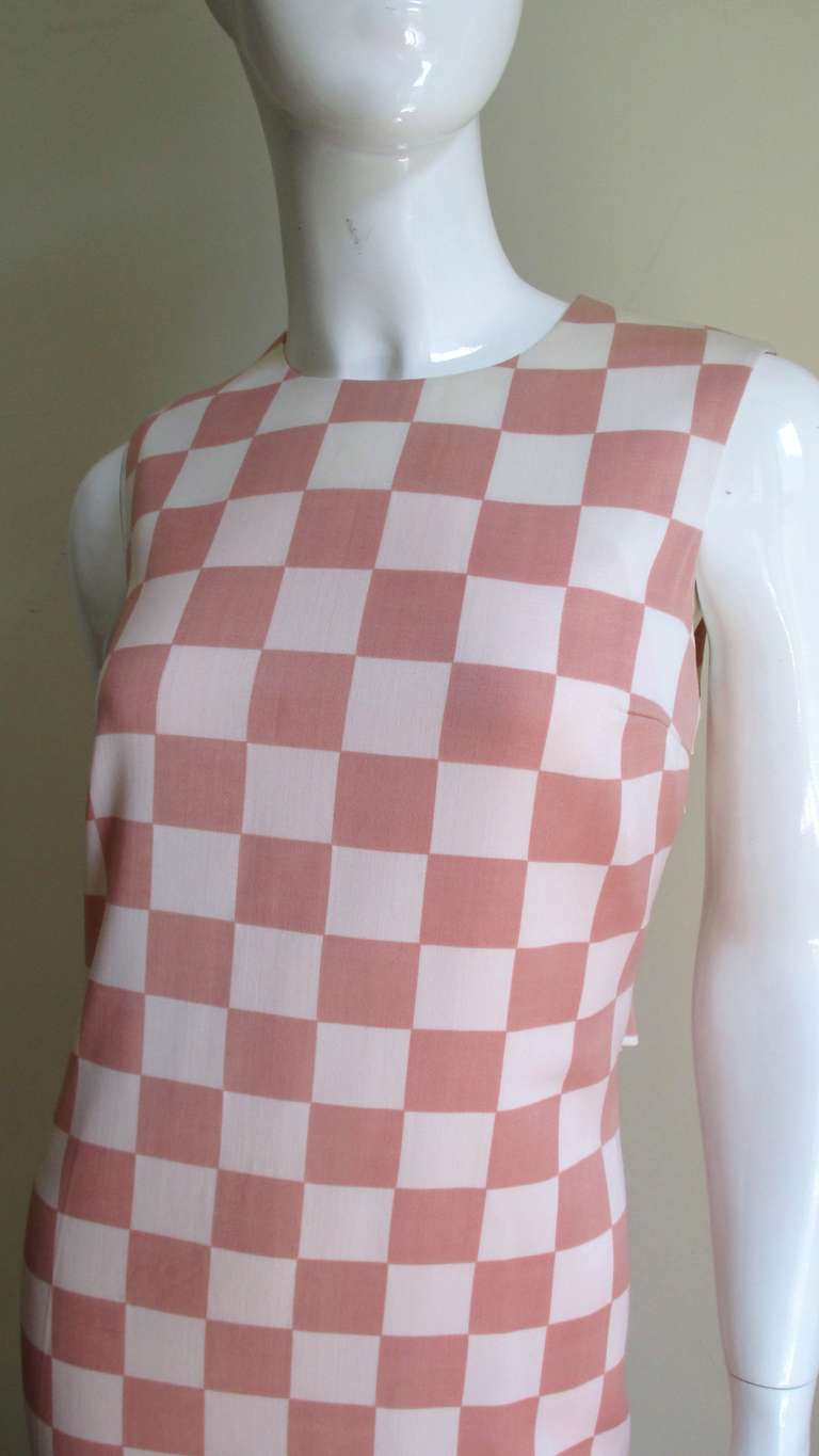 A great light weight wool pink and off white large check dress from Gianni Versace Couture.  It is a simple sleeveless shift style with a 3 piece back half belt held together with matching pink Greek Keys in scripted Versace buttons and bound