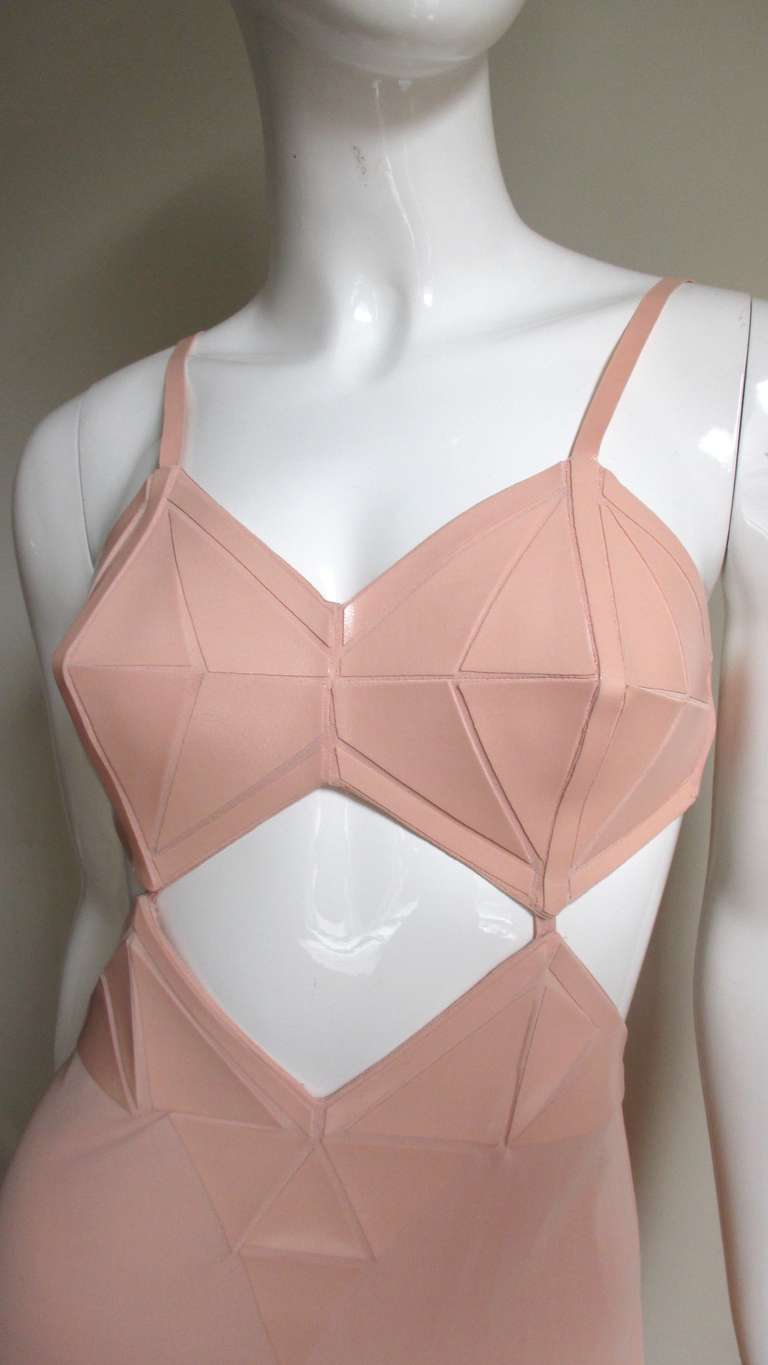 An amazing dress from Jean Paul Gaultier in a fleshy peach silk with stunning matching road warrior meets Madonna leather like triangles adorning the cups of the (adjustable strap) bra and around the 3 angled midriff cutouts coming to a V in the