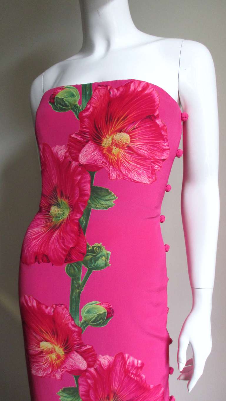 A stunning silk dress from Bill Blass in bright pink highlighted with screen printed flowers down the length of the front and back.  Fitted, strapless with a separate boned inner corset (for support and top hold the dress securely in position) and