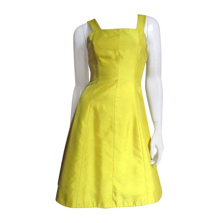 A beautiful vibrant yellow silk from Claude Montana. It is simple from the front with a square neckline, princess seaming for a great fit and an A line skirt.  The back the straps meet a band mid level with a cutout beneath.  It has matching silk