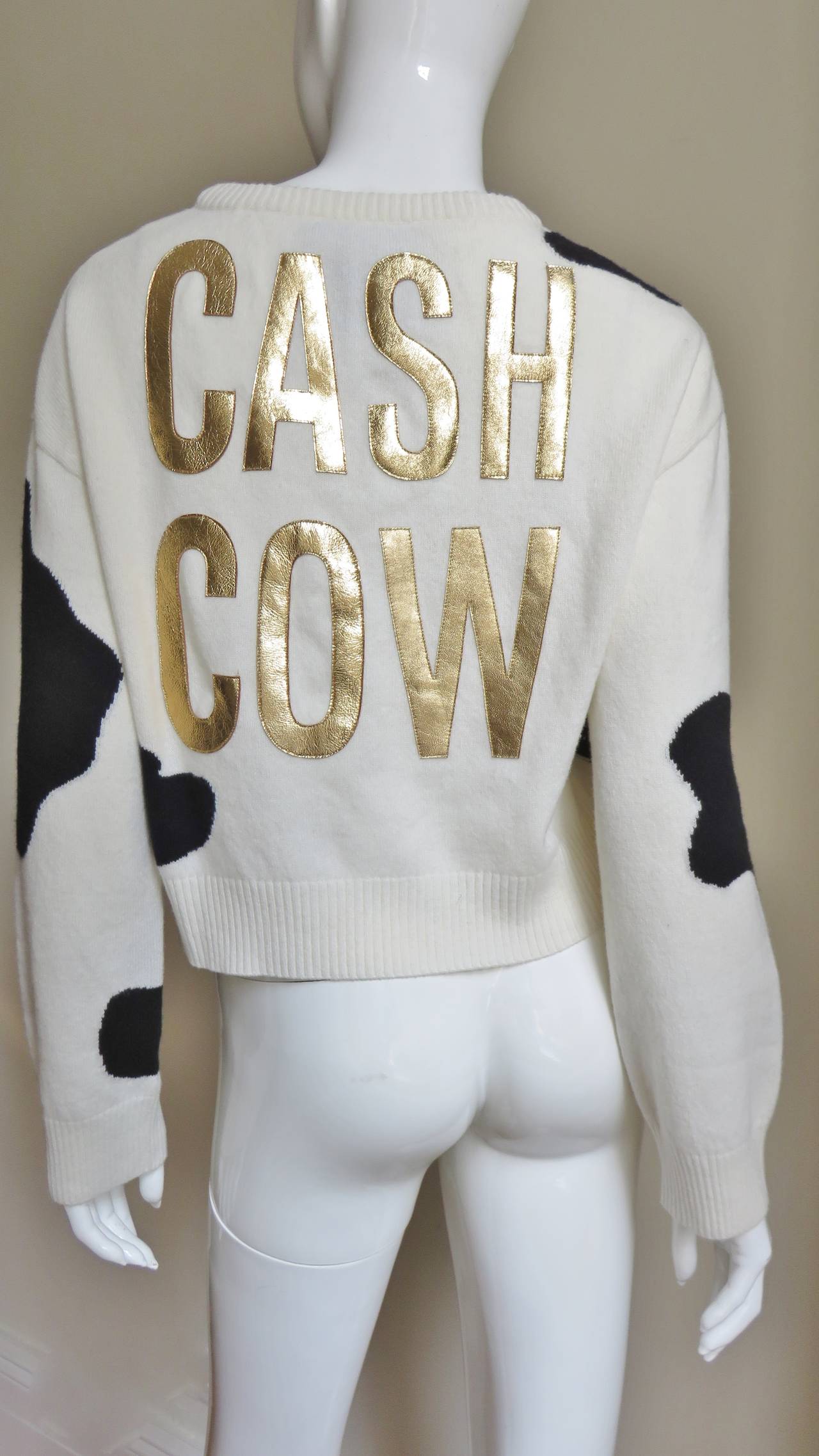 A fabulous long sleeve, crew neck cashmere sweater from Moschino Couture with 'CASH COW' emblazoned in gold letters individually sewn onto the back of the cow fur pattern in black on off white.  Slips on over the head.
Fits sizes Medium, Large. 