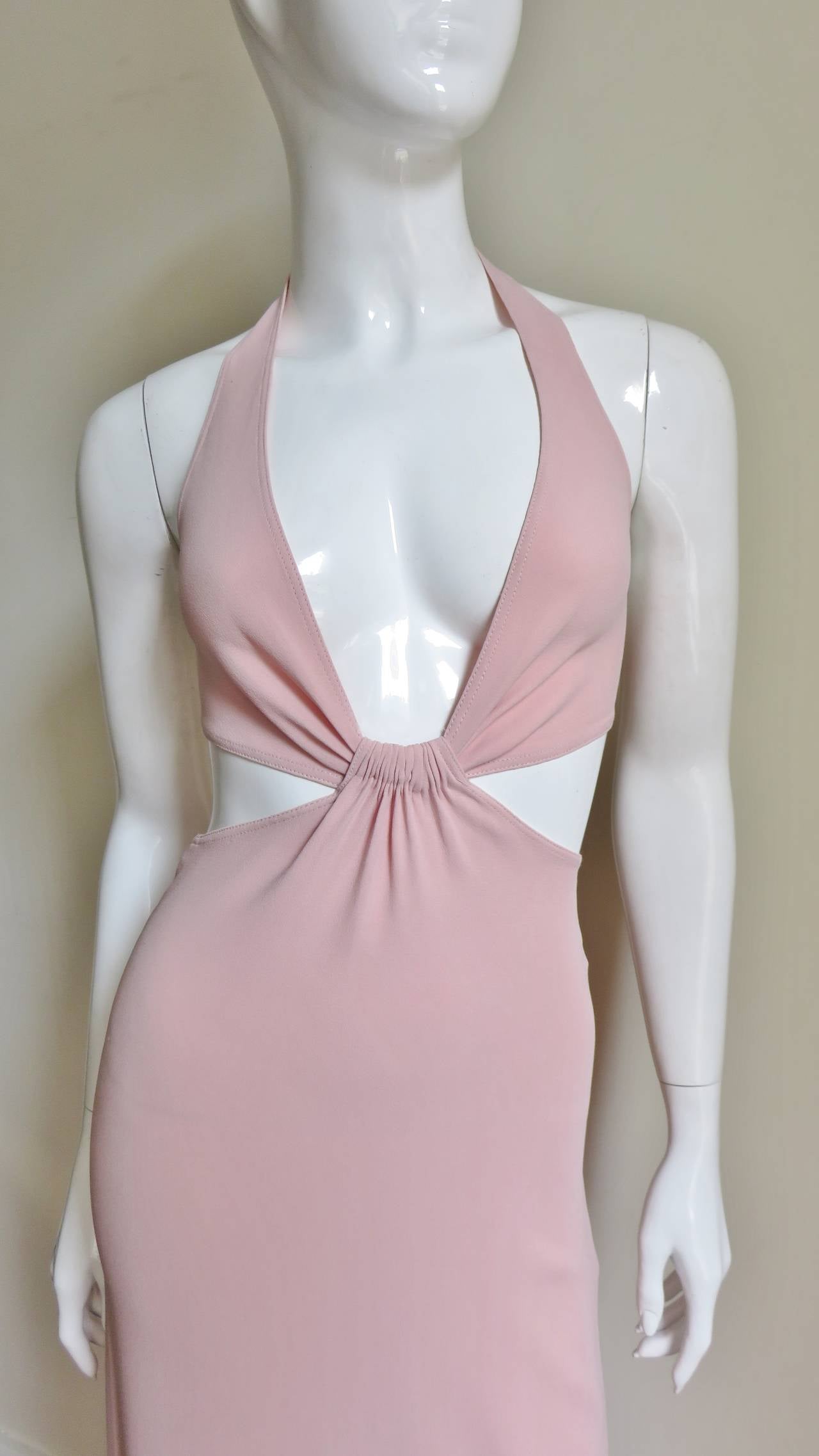 A fabulous blush pink silk knit dress from Celine. It a halter style top with a  plunging front and bare in the back with the exception of a strap across the center closing with a metal clasp. The skirt forms from the gathered center front of the