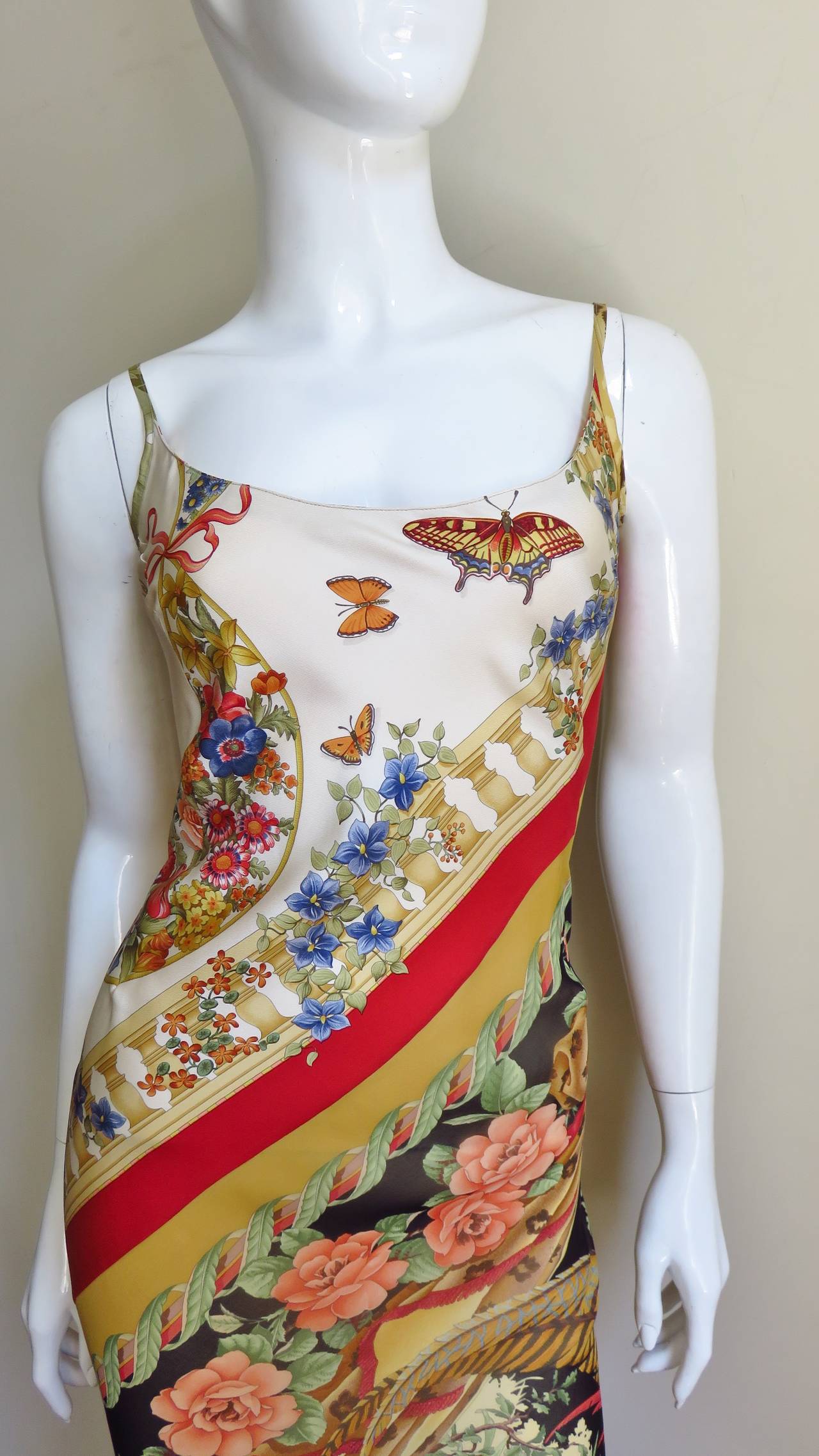 A beautiful silk dress from Italian designer Salvatore Ferragamo.  It is created with silk in a variety of patterns including a duck, flowers, birds and butterflies all intricately detailed and colorful.  It has spaghetti straps, trumpets slightly