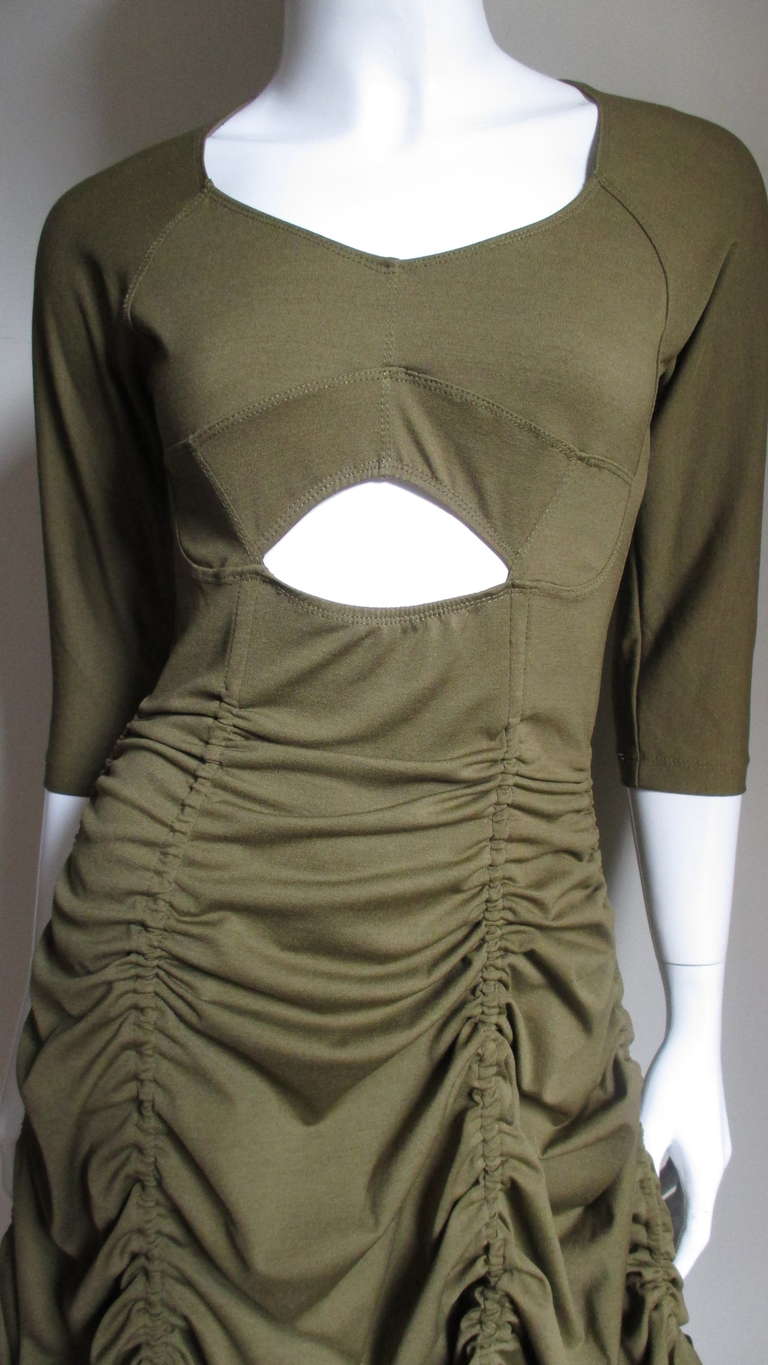 A great dress from Jean Paul Gaultier's vintage Junior Gaultier line.  Made of a light weight olive green wool jersey it has 6 amazing adjustable drawstrings which can shorten or lengthen the skirt.  It has elbow length sleeves, a scoop neck and