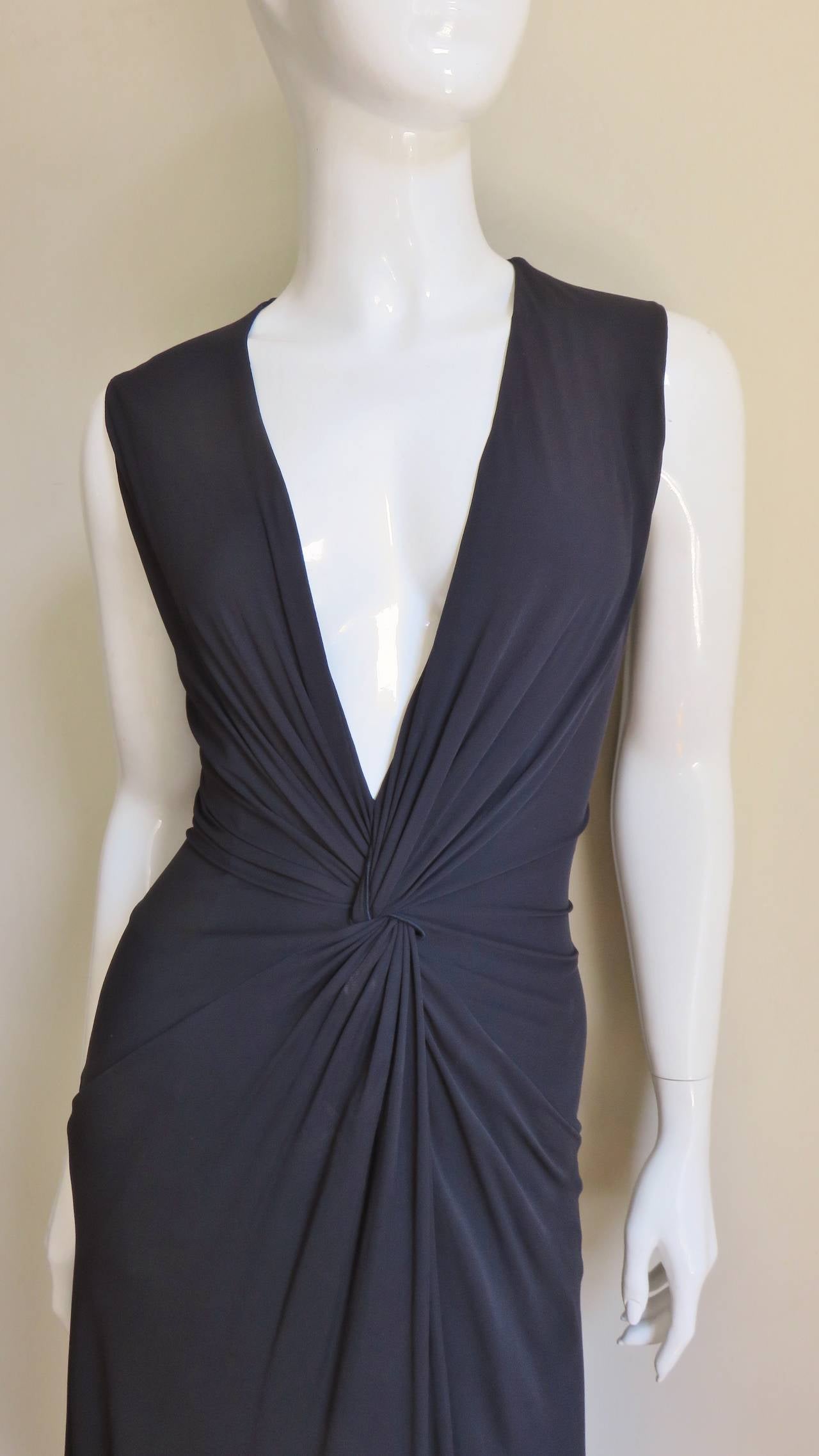 A fabulous rich fine black jersey dress from Alexander McQueen.  Very flattering with a deep plunging neckline and gathering meeting at the center front waist.  Built into the design in the gathers at a seam to the hip lies a pocket on either side. 