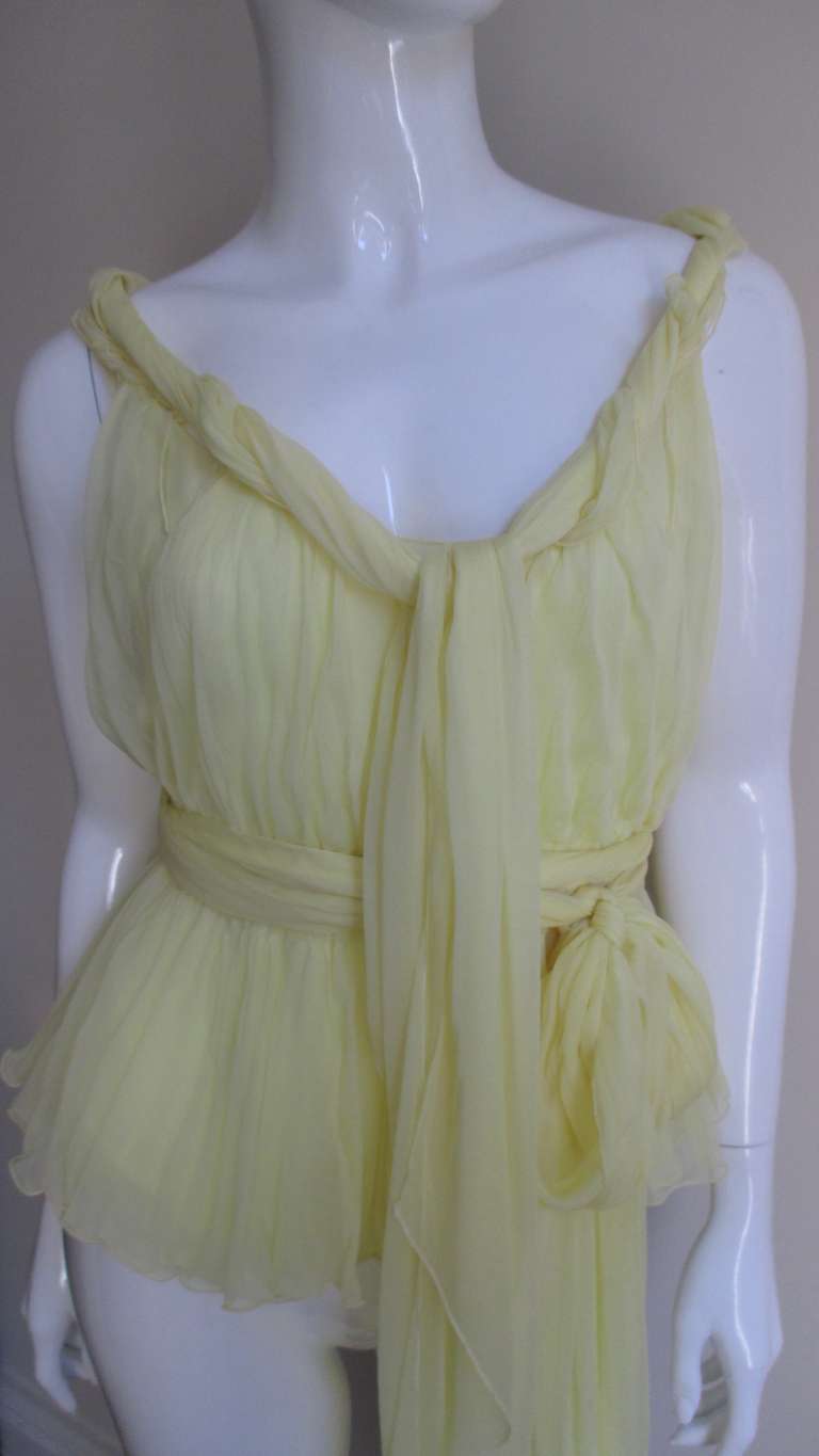 Absolutely gorgeous blouse/shirt from YSL in lemon chiffon silk.  It has adjustable straps the continue from the front and back gathering in twists and turns with long ties in the front.  The waist has an adjustable drawstring with long ties as well