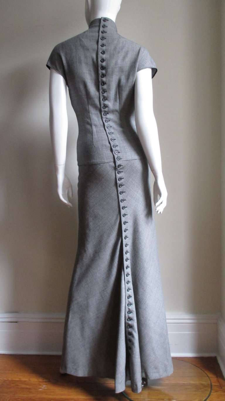 An amazing black and off white woven wool maxi dress.  The fit is stunning with a stand up collar, cap sleeves and a pointed, tucked bodice that fits into a wide hip level banded waist in front.  The back bodice is one piece and has darting that