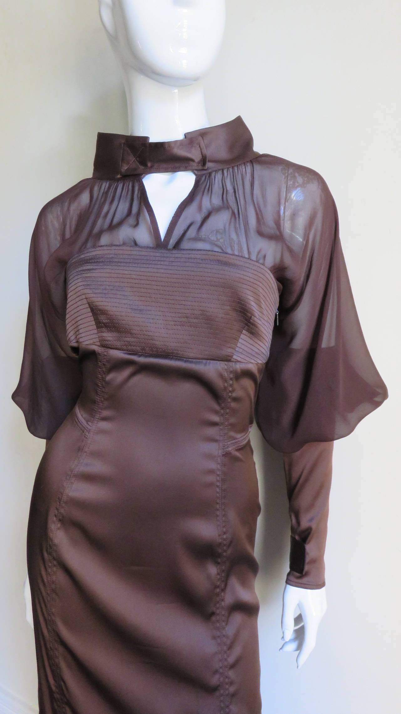 A gorgeous dress from Tom Ford for Gucci in a rich chocolate brown stretch silk.  The bodice has a top stitched strapless portion with sheer chest and upper back including a stand up collar in the dress fabric. The sheer upper dramatic leg of mutton