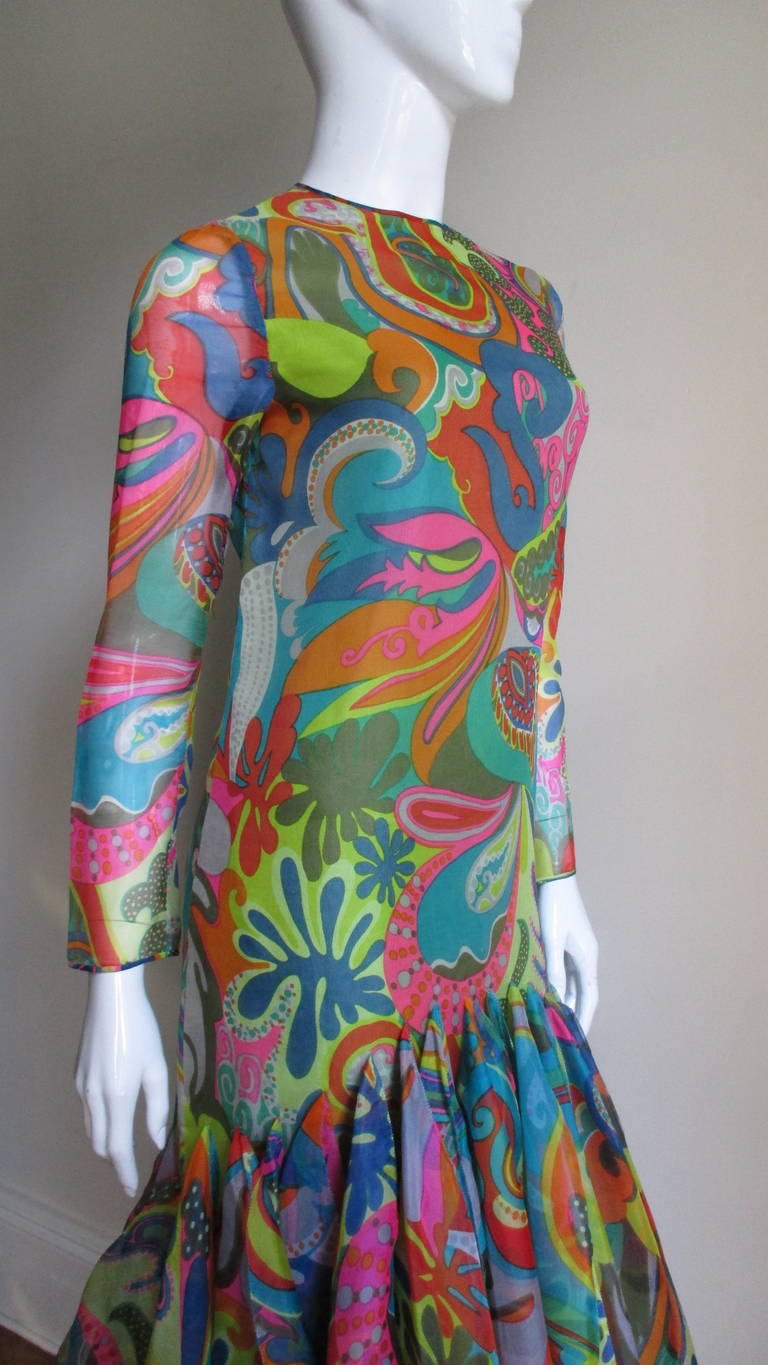 An amazing example of Pierre Cardin's couture work in a colorful psychedelic silk print.  It is long sleeved with a crew neck and skims the body to the thighs. It then explodes in cacophony of large circular orbs each stitched vertically along their