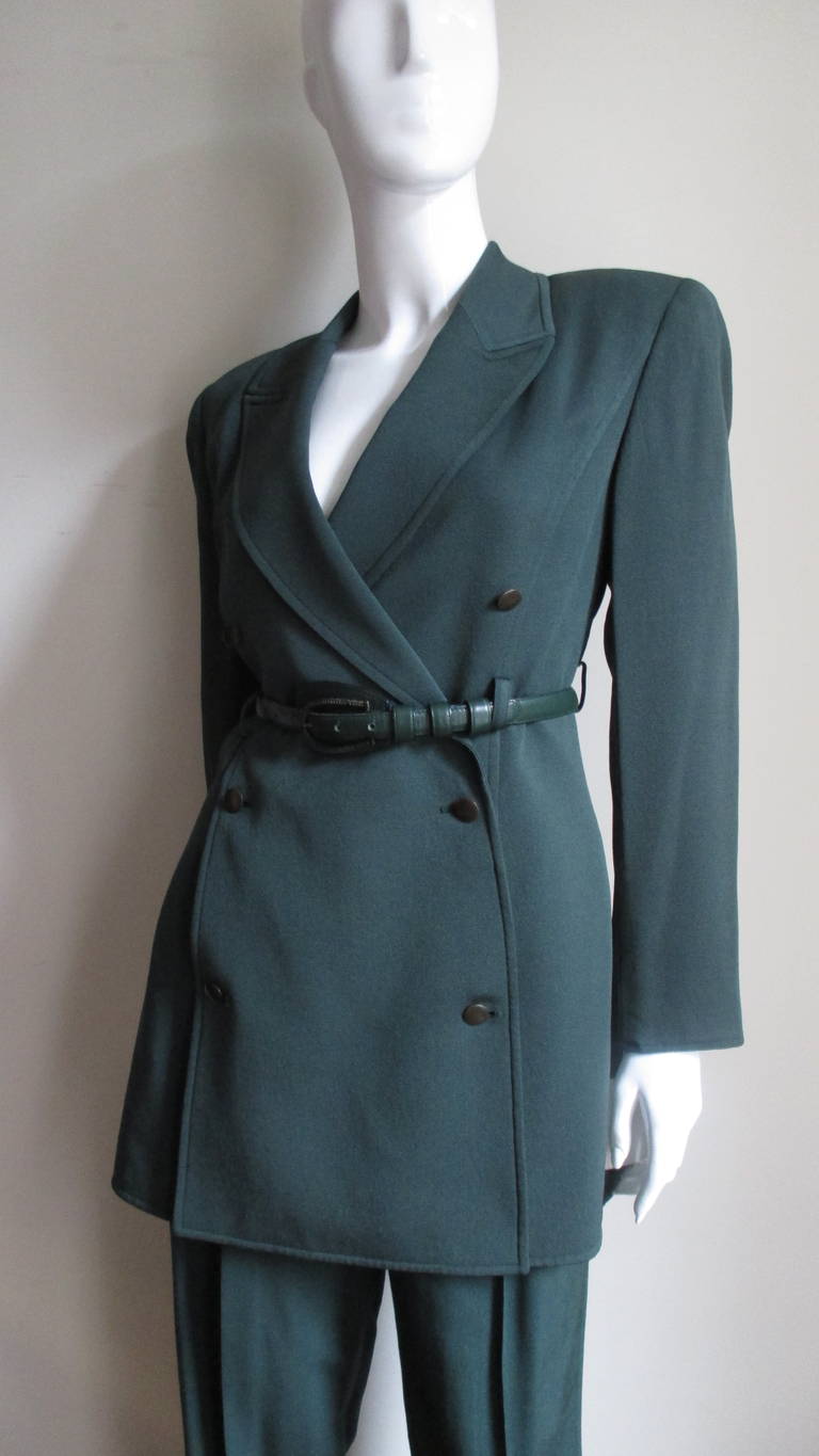A fabulous forest green wool jacket, skirt and pants set from Claude Montana.  The jacket is double breasted with a matching green leather belt and buttons, princess seaming, padded shoulders and front seam pockets.  The straight leg pants have a