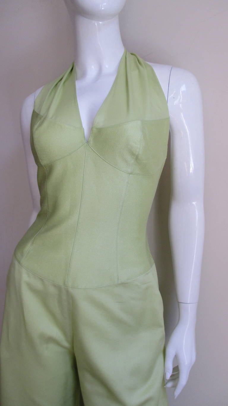 A fabulous halter jumpsuit from Thierry Mugler in a soft lemon lime synthetic blend with an almost imperceptible sparkle.  The fitted corset portion of the jumpsuit is of the same fabric in a stiffer form with seamed cups and  straps that wrap