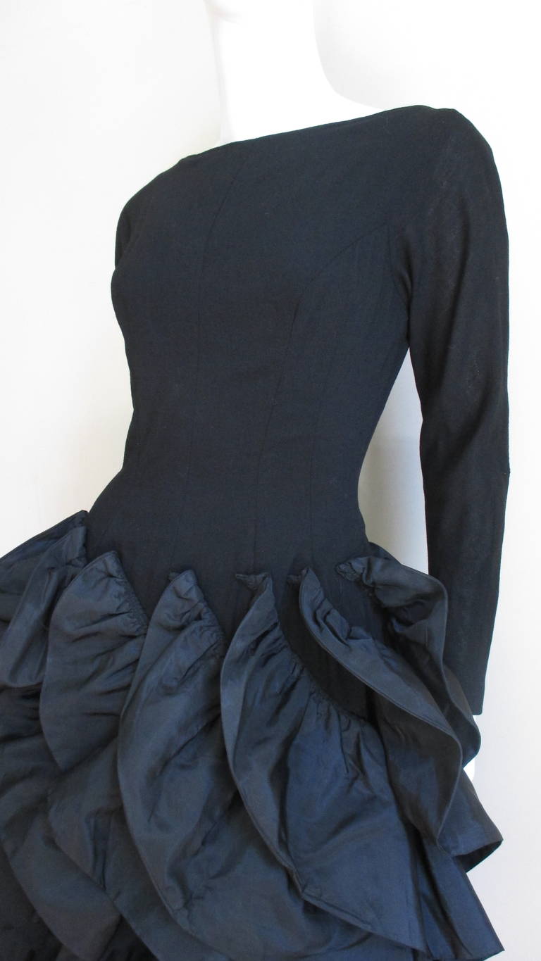 A fabulous light weight black wool dress by Betty Carol.  It has princess seaming for a great fit and a V cut back.  The wow factor is the skirt completely adorned with spiraling rows of firm stand out taffeta ruffles.  They are seamlessly applied