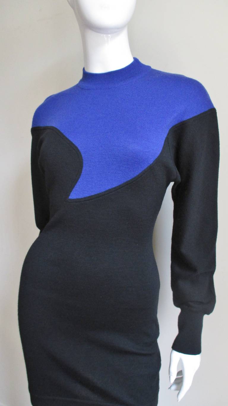 A fabulous fine wool knit dress in black and bright blue from Claude Montana. The dress has a crew neck, long sleeves with ribbed cuffs and a bright blue inset asymmetric curved yoke on the front and straight across the shoulders in the back. Easy