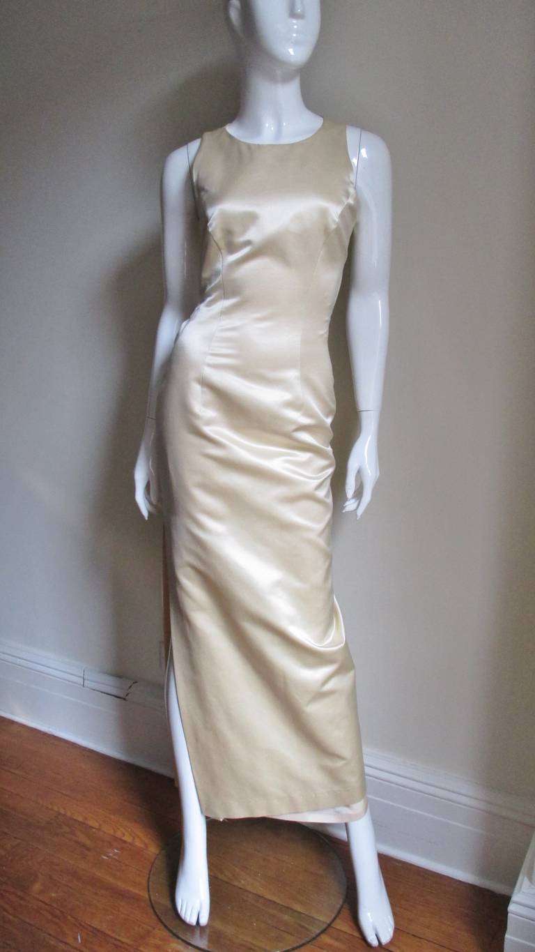 A very elegant off white silk full length dress from Sophie Sitbon. A simple princess seam fitted dress from the front.  The back is cutout from just below the shoulders to just below the waist crossed with matching lacing.  It has a side slit, a
