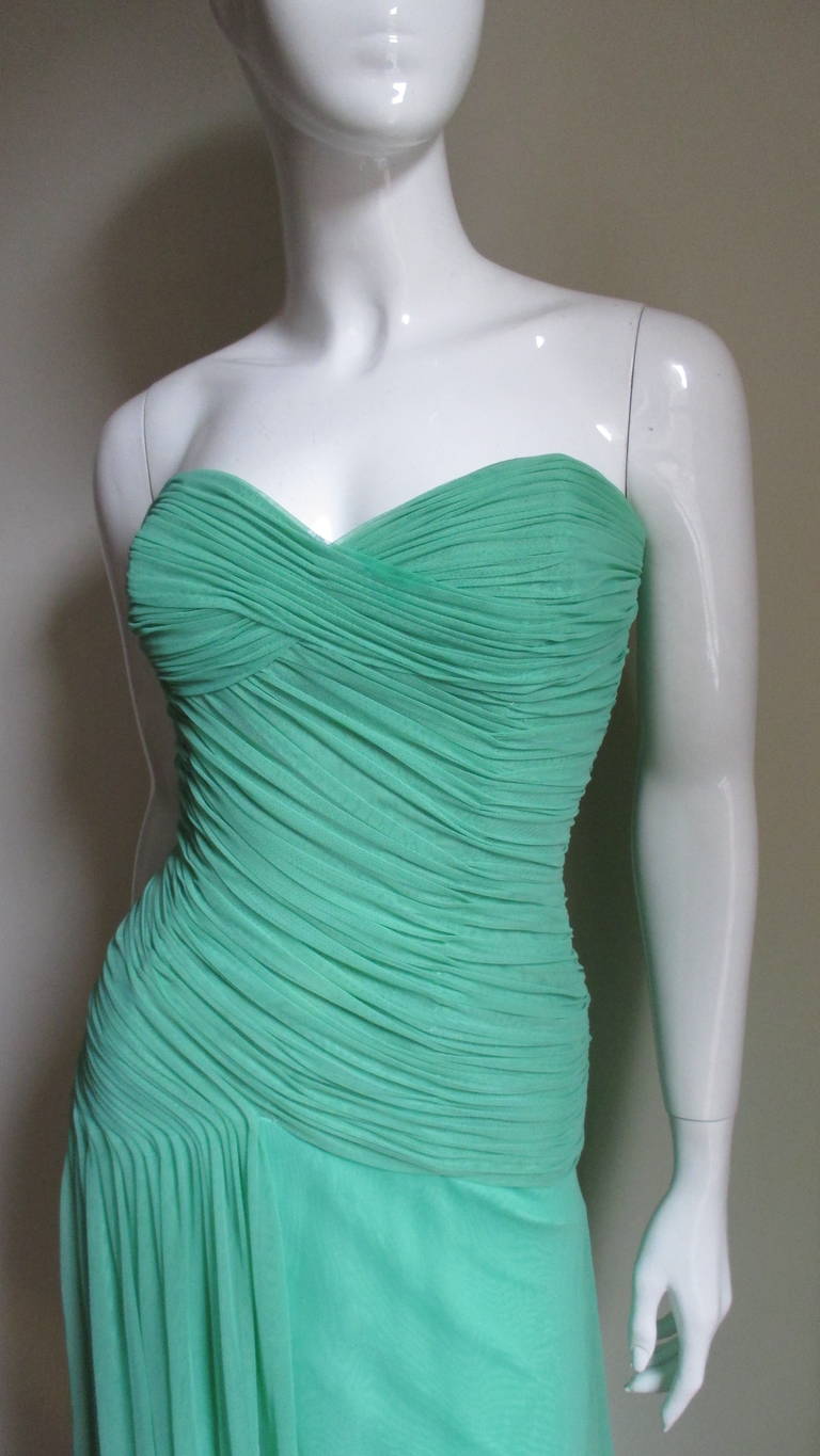 A fabulous mesh dress from Vicky Tiel Couture in a beautiful shade of green.  It is a boned corset style with ruching flatteringly crisscrossing the bustline, wrapping around the waist then trailing down one hip in soft folds.  It is lined in