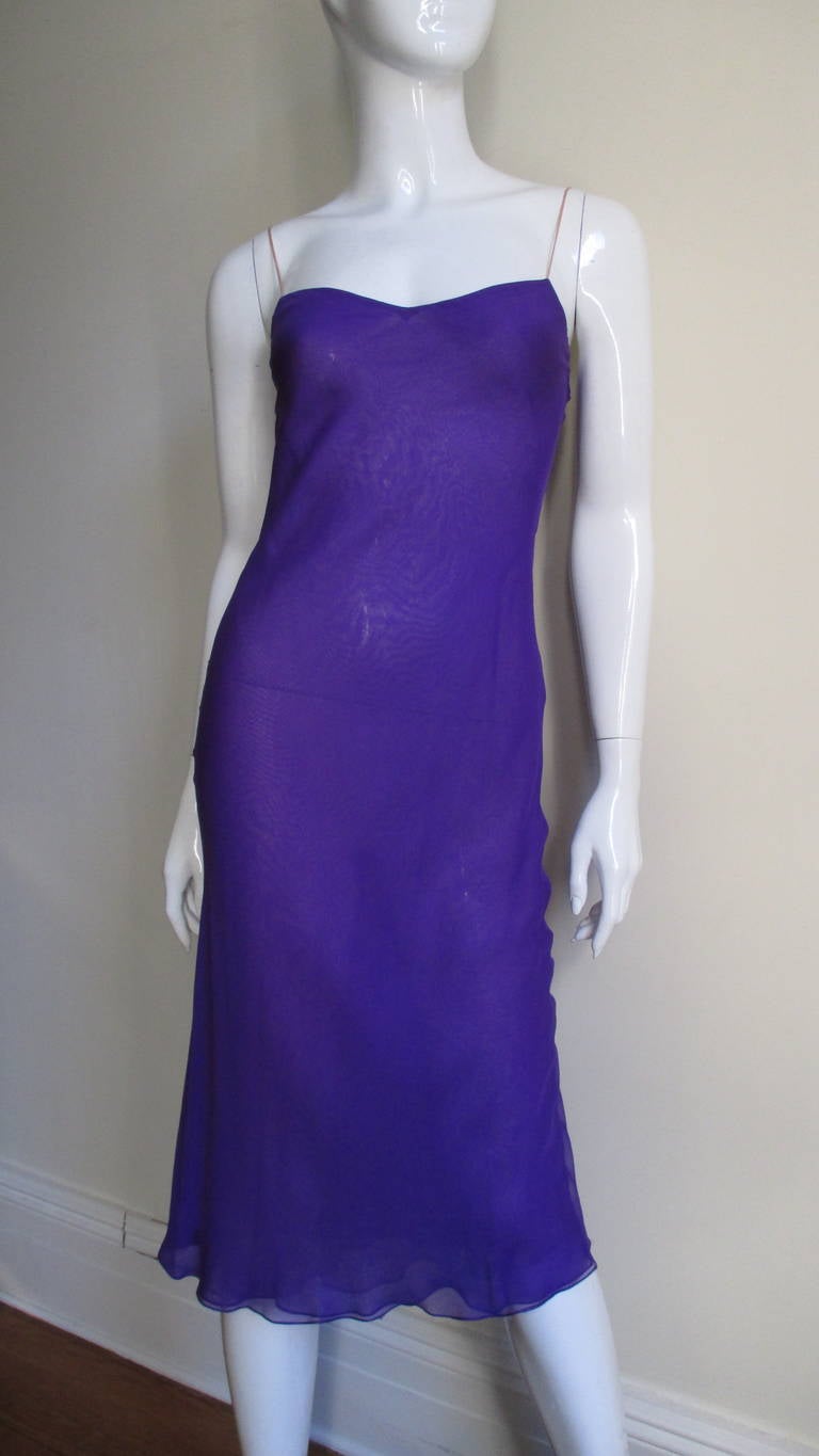 A beautiful bright purple silk caftan, slip dress and sash combination for the master Halston.  The slip dress skims the body and has nude spaghetti straps giving the impression of it being strapless.  The overdress is caftan style with dolman