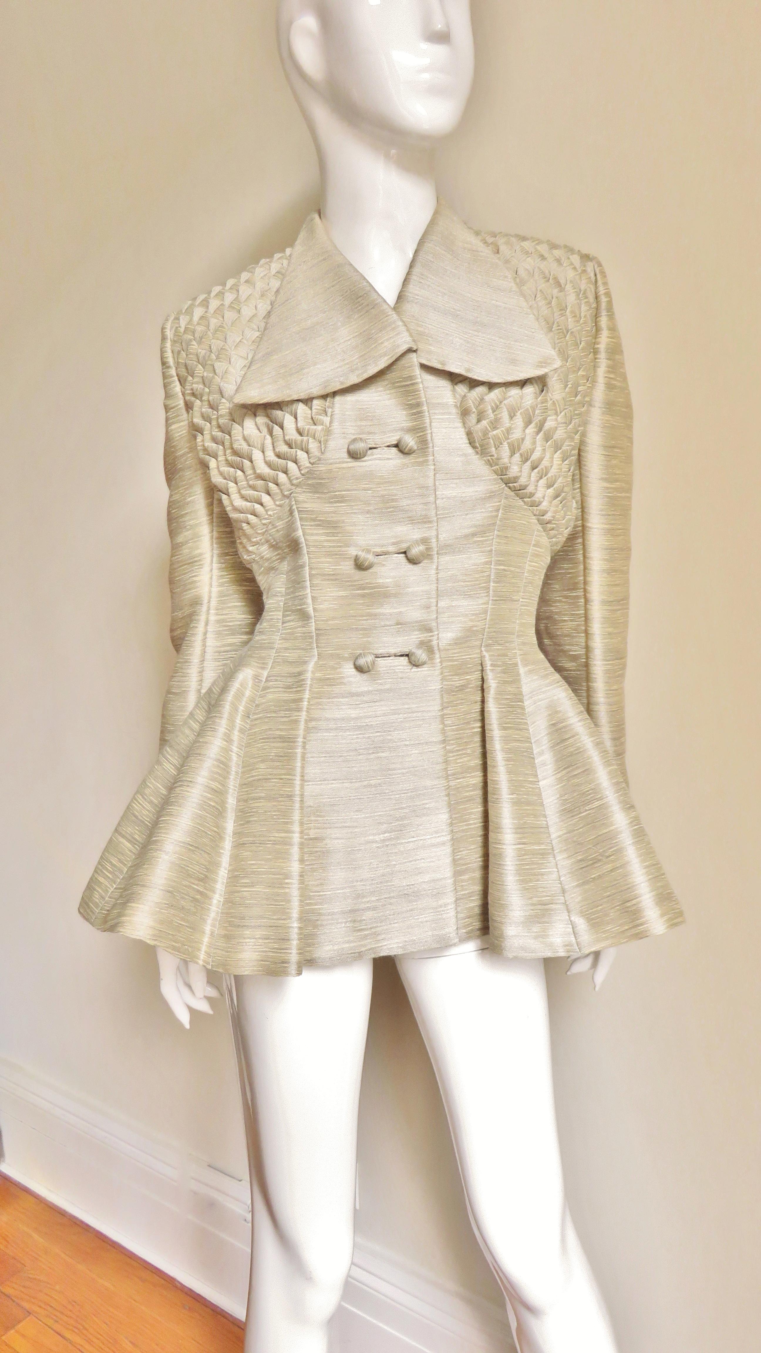 A fabulous beige and grey silk and wool fitted 1940's jacket from Lilli Ann.  The double breasted jacket has a winged front collar, long sleeves with fold back cuffs and front self covered ball buttons with bound buttonholes. There are intricately