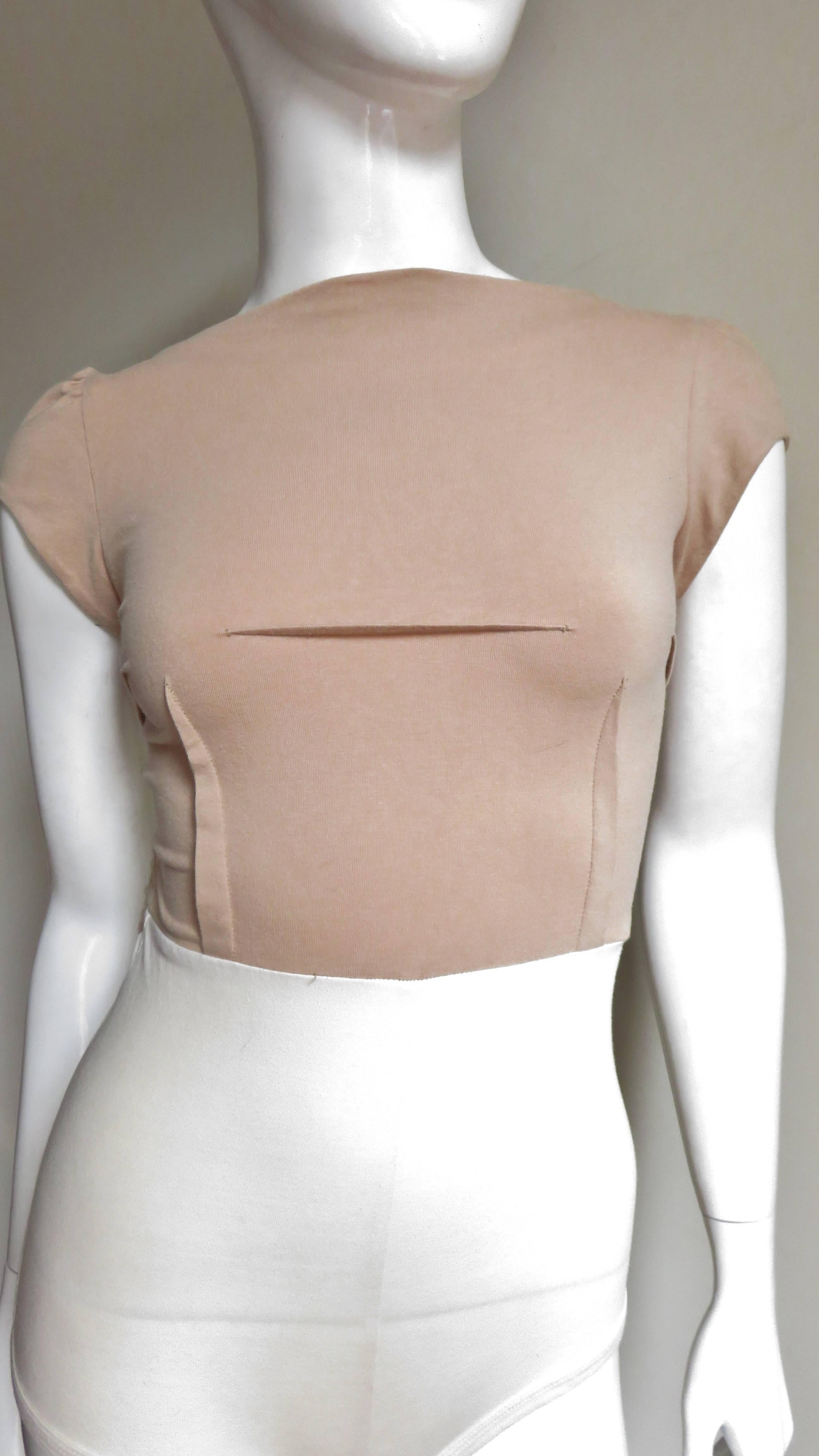 A fabulous early piece from Belgian designer Martin Margiela.  Never worn it is a cotton knit body suit with a low scoop back, small cap sleeves and a dart detailed front.  The top portion is light tan and the bottom is off white.  The casing for