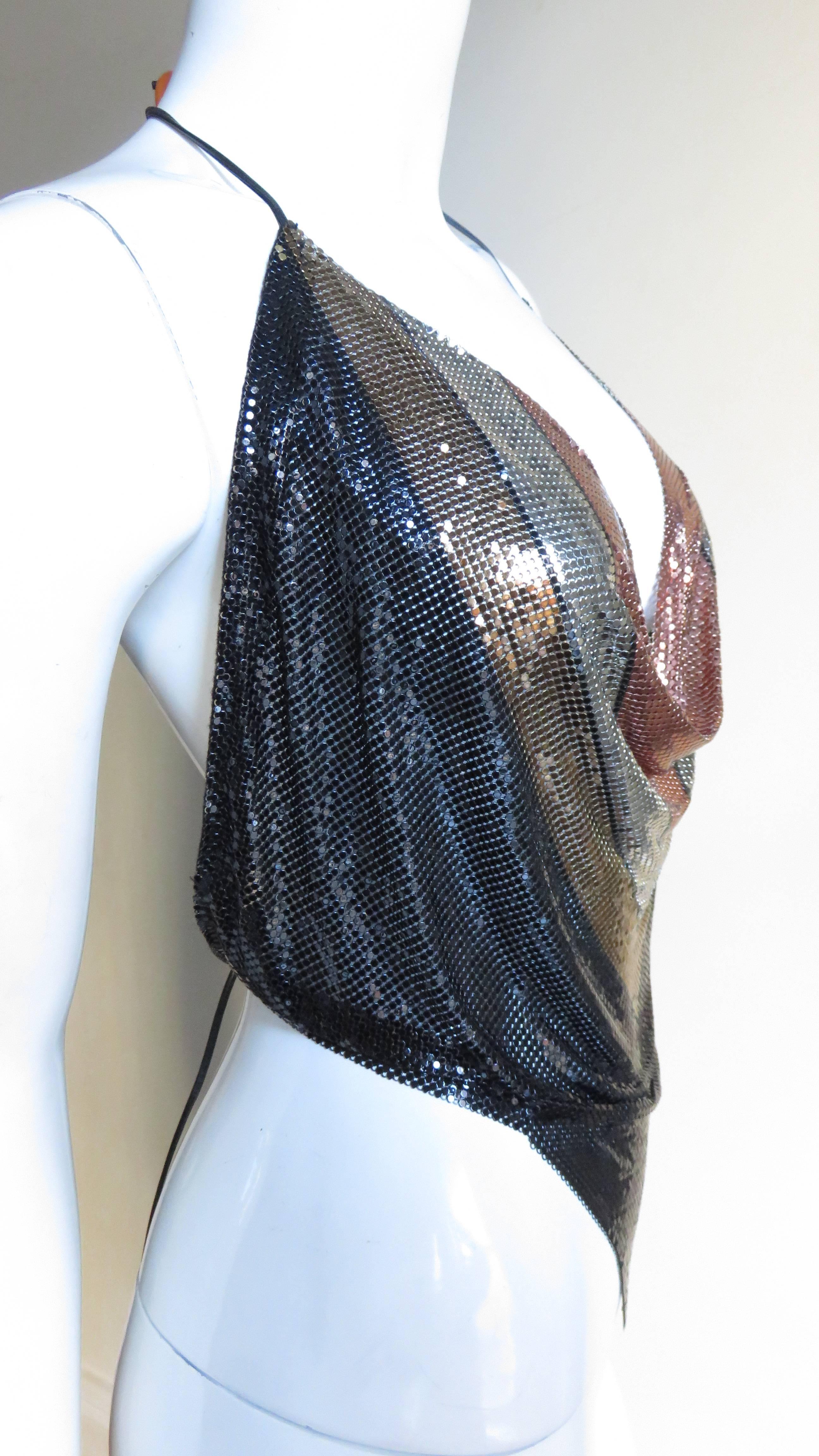 A great throwback to the 1970's from masters Whiting and Davis- a metal mesh halter top.  The pattern is linear blocks of colors in copper, gold, silver and black.  The neckline drapes with the amount of exposed decolletage controlled by leather
