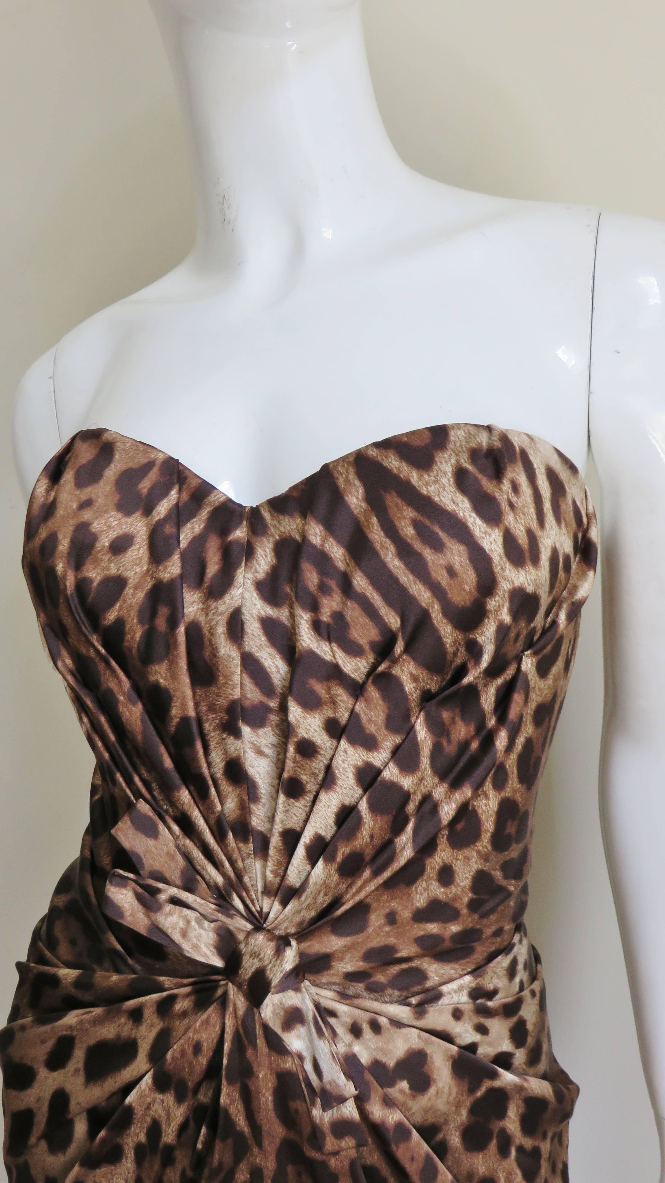 A stunning stretch silk leopard print bustier dress from Dolce and Gabbana.   It bodice has an inner boned corset.  There is ruching emanating from the front waist creating a flattering cinched waist silhouette, in contrast the back is smooth.  The