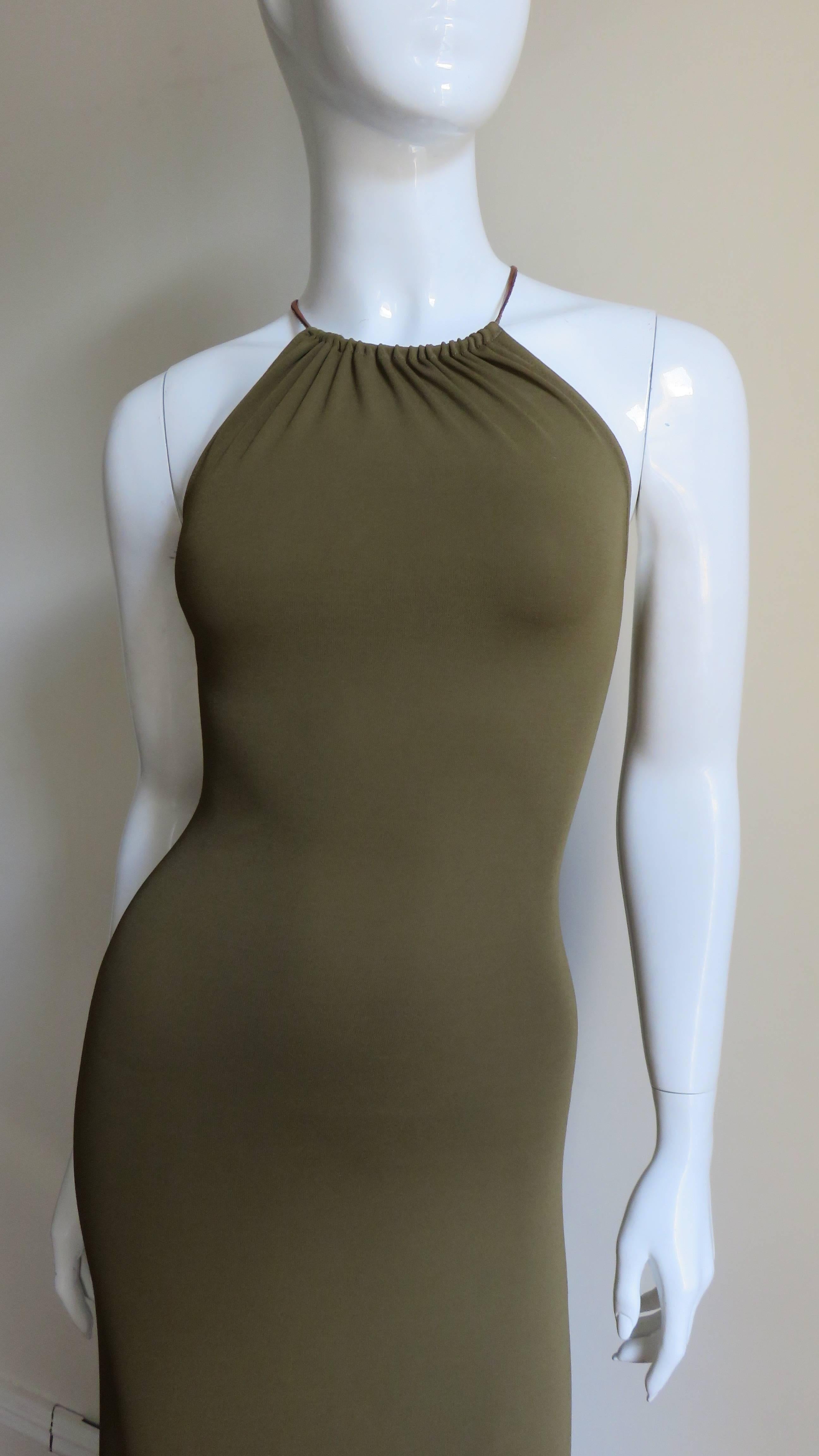 A fabulous dress from Celine in olive jersey.  It is fitted through to the hips and flares slightly toward the midi length hem.  The back is plunging with leather laces criss crossing the back.  It is unlined, slips on over the head and laces have