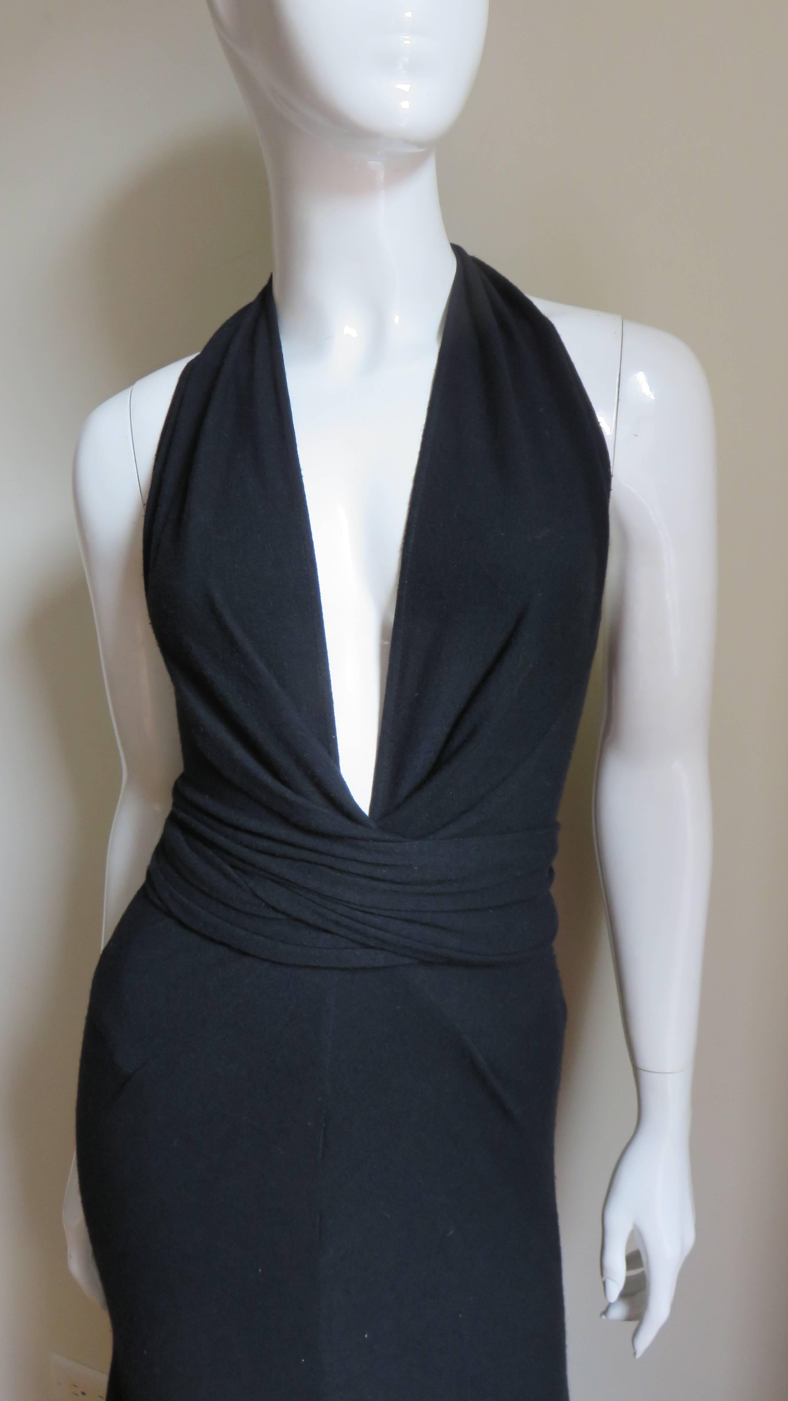 A fabulous black silk jersey maxi dress by Donna Karan.  It has a deep plunging neckline and ties that wrap around the waist.  The skirt portion hugs the hips then flares to the hem.  It is unlined and slips on without closures.  Excellent, unworn