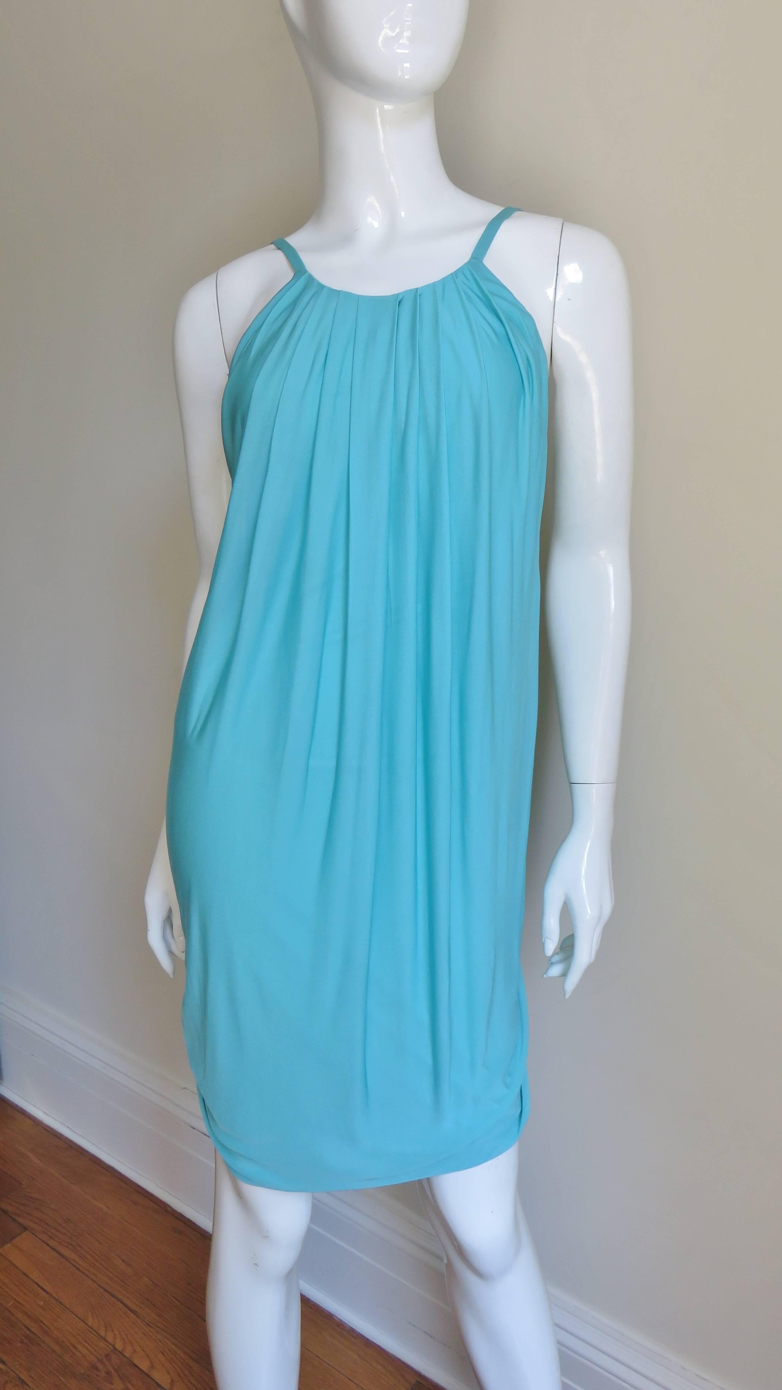 A very sexy dress in aqua silk knit. An easy breezy summer dress that just slips on but creates drama with the back cutout to just above the derriere.  It has spaghetti straps from which tucked fabric falls creating a slight bubble effect.  It