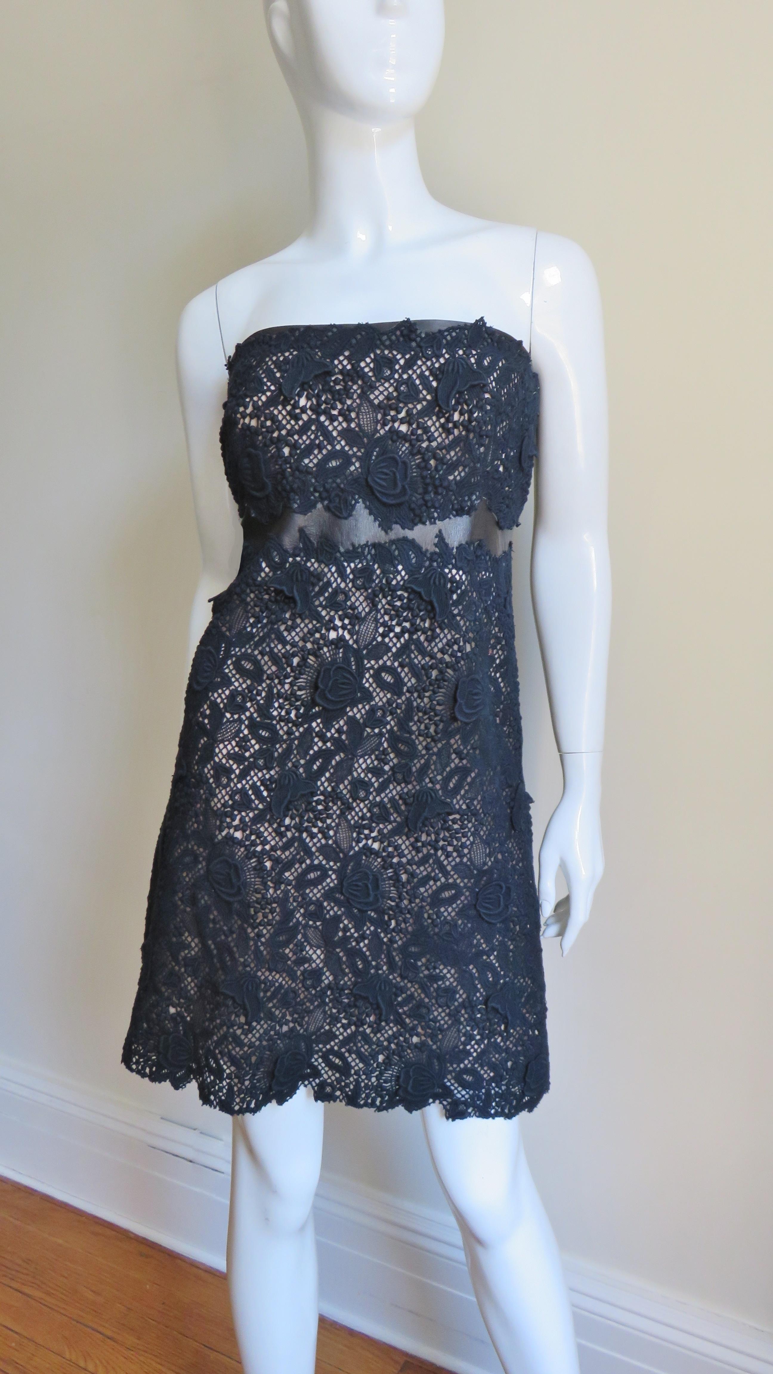 A fabulous strapless black lace dress from Valentino.  It has a leather band above and below the bust peaking out through the natural line of the lace's edge.  The skirt has a gentle A line with the hem again following the pattern of the lace. 
