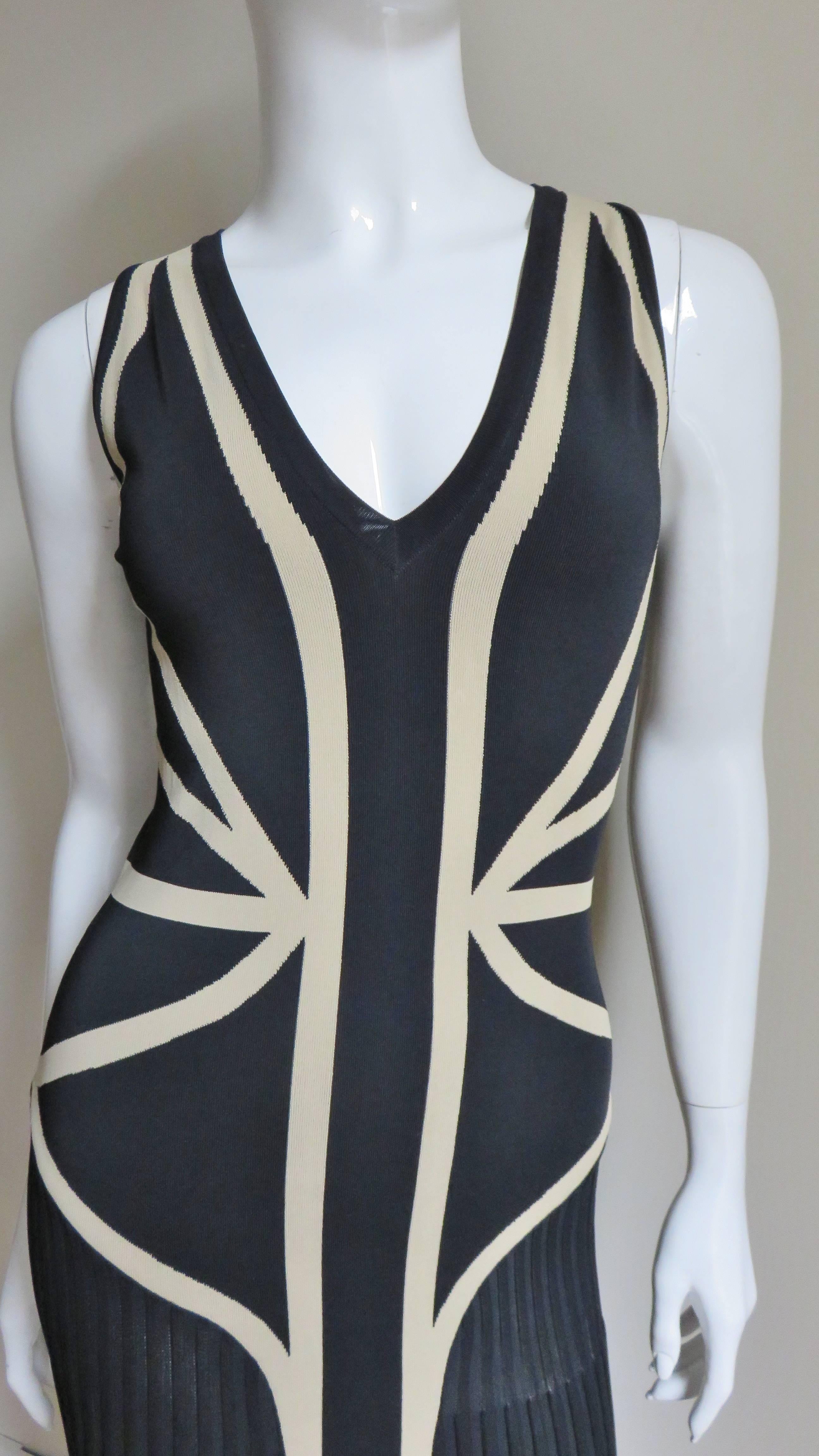 A beautiful dress from Alexander McQueen in back and beige stretch bandage fabric.  It is sleeveless with a V neck flattering with the strategically placed lines of beige cinching the waist.  It is unlined and slips on over the head.   
Appears