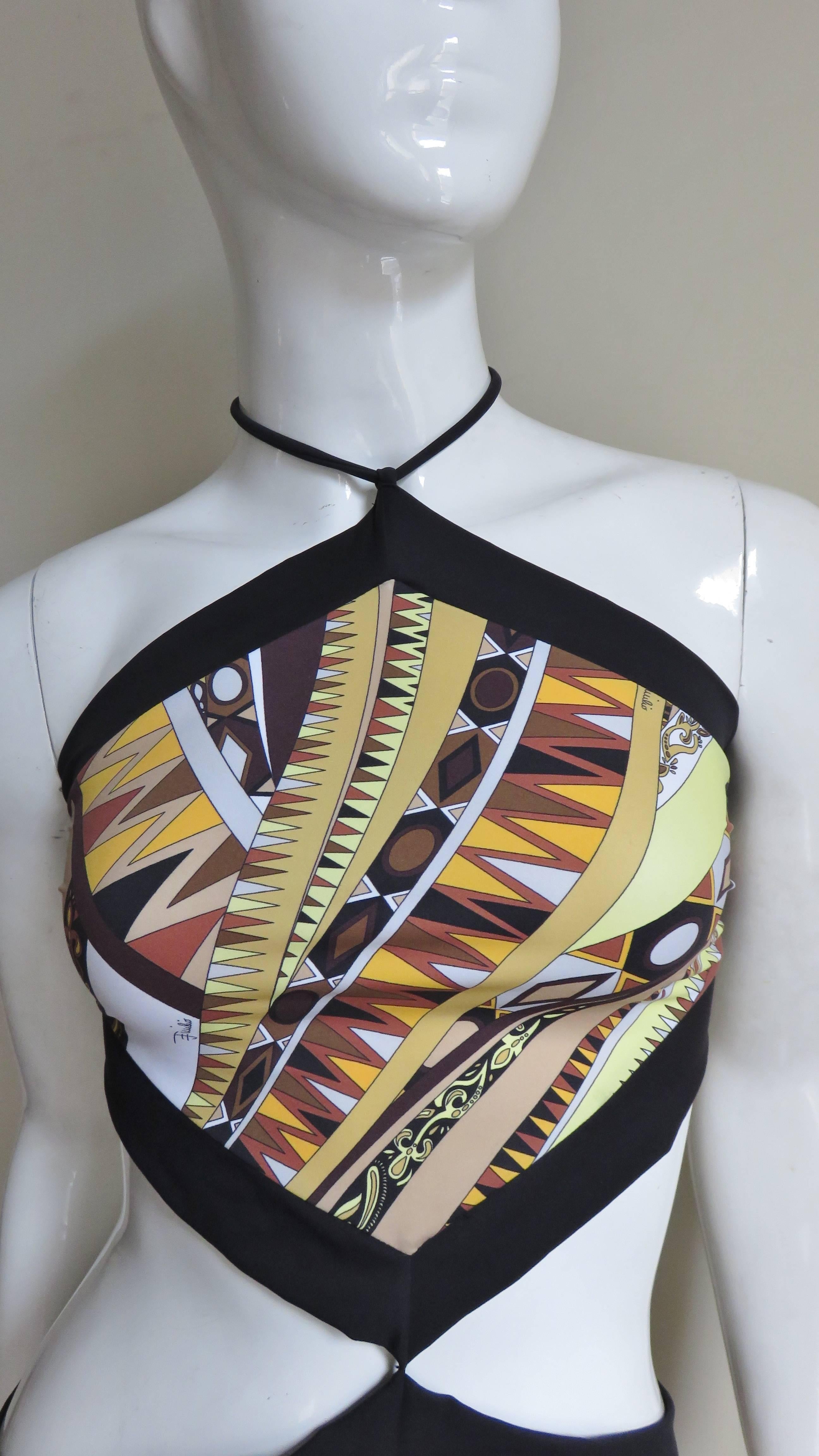 A fabulous monokini from Emilio Pucci.  It is comprised of the intricate geometric mod pattern Pucci is famous for in green, gold, yellow, beige, orange and brown intermittently marked with the Emillo signature. The top and bottom are connected by